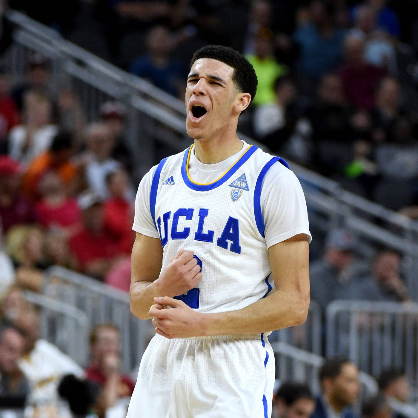 籃球 桌布 壁紙 — 一位UCLA籃球運動員在比賽中激情吶喊，球迷們在看台上觀看。