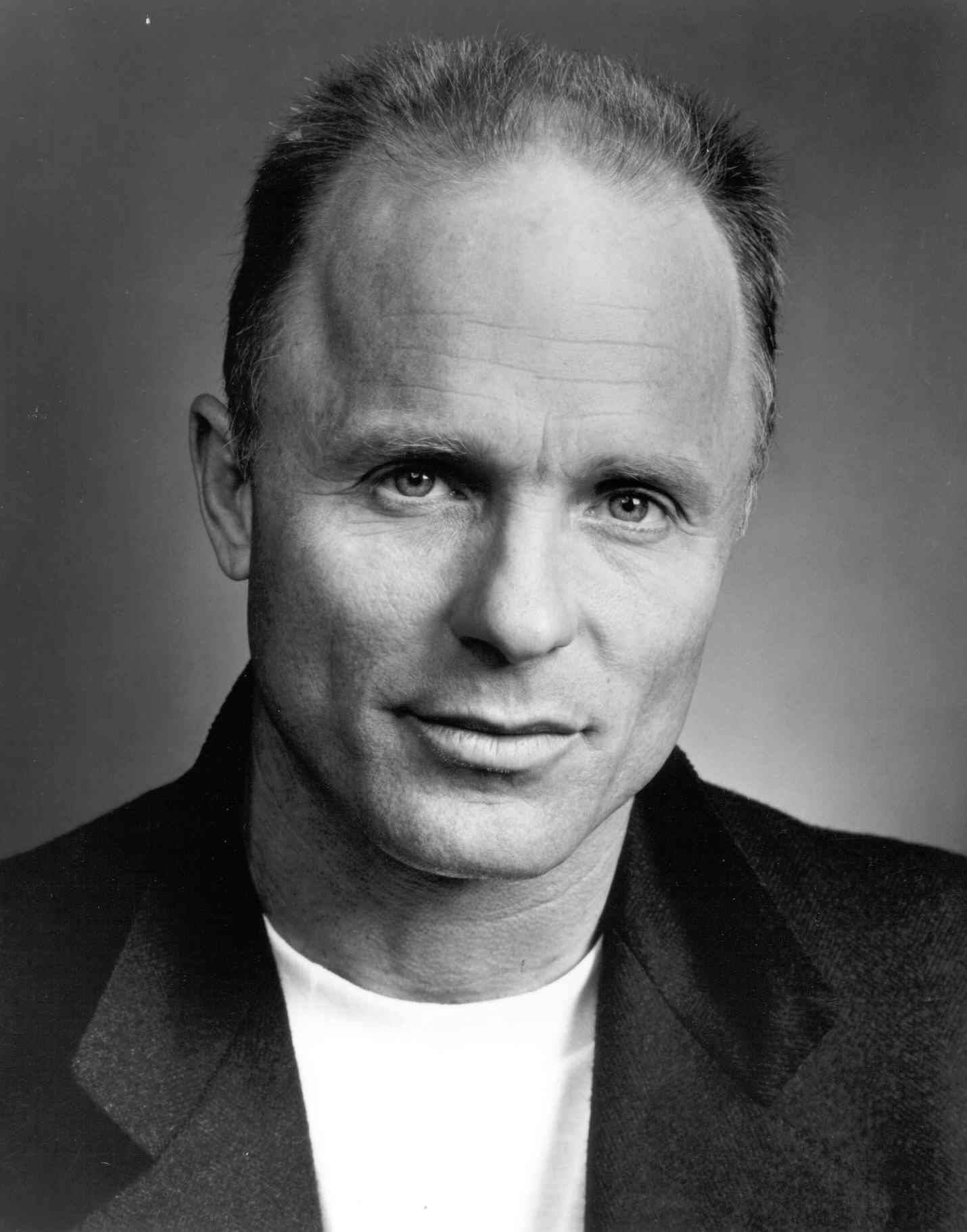actor 桌布 壁紙 — 一位中年男子穿著深色外套內搭白襯衫，表情嚴肅的黑白肖像照。