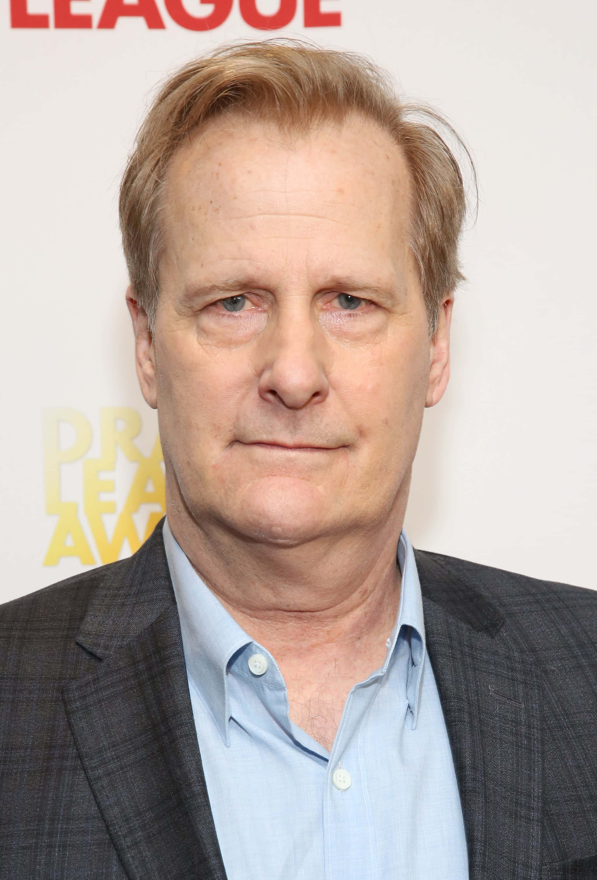 Jeff Daniels 桌布 壁紙 — 一位中年紅髮男子穿著灰色西裝和淺藍色襯衫在頒獎活動中的特寫照片。