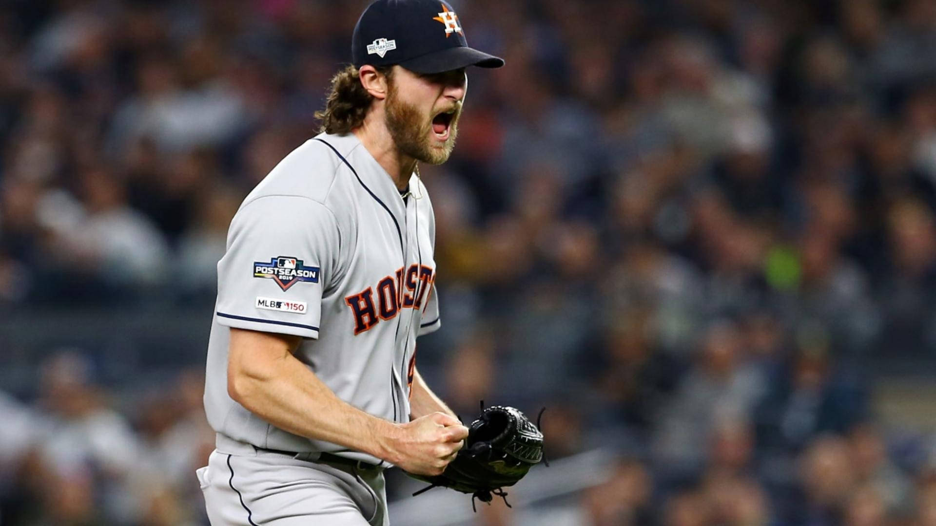 Gerrit Cole 桌布 壁紙 — 一位休士頓太空人棒球投手在夜間比賽中發出強烈情緒的怒吼，身後是模糊的人群。