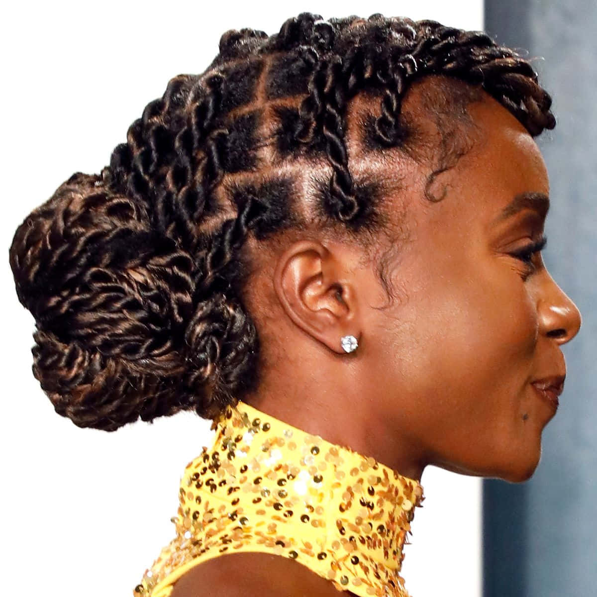 Hairstyle 桌布 壁紙 — 一位側面女士，梳著精緻的辮子盤髮，戴著閃亮的黃色亮片上衣和鑽石耳環。
