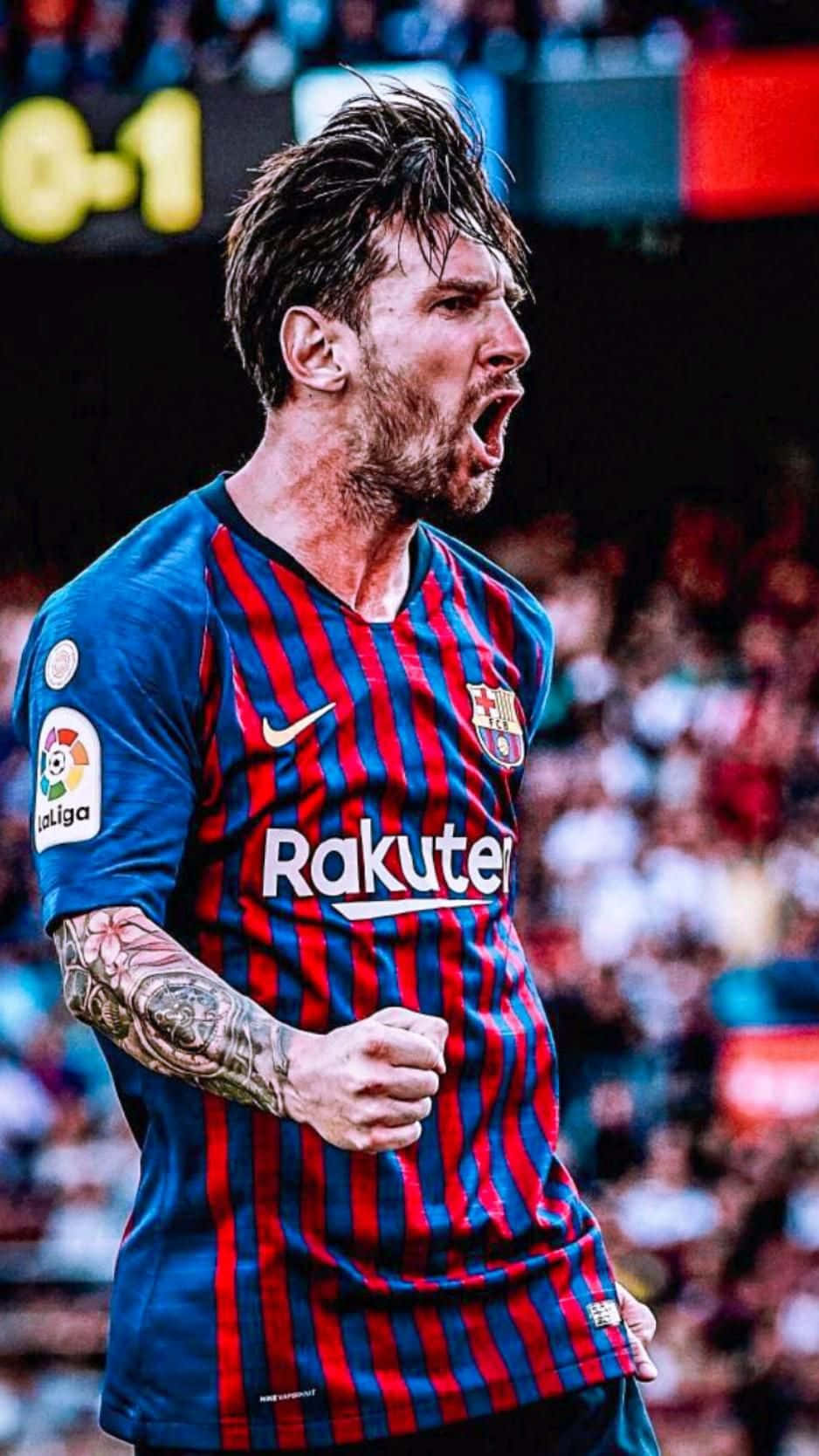 Messi Cool 桌布 壁紙 — 一位充滿熱情的足球員身穿紅藍間條球衣，紋身手臂緊握成拳，勝利咆哮。