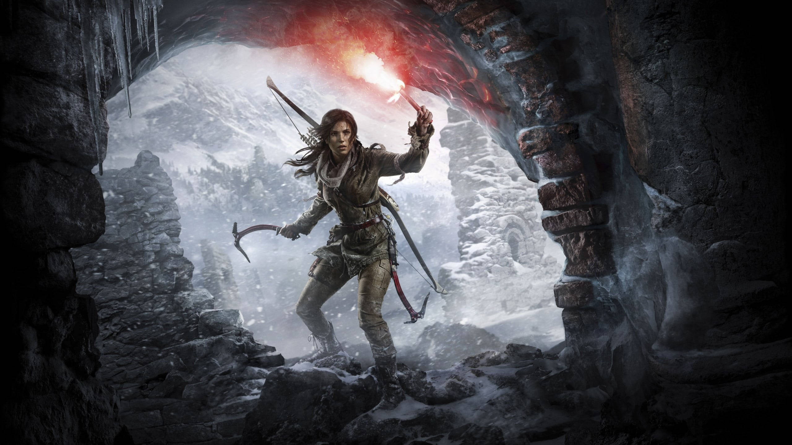 Rise Of The Tomb Raider 桌布 壁紙 — 一位兇猛的女冒險家站在雪洞入口，手持燃燒的火把和冰斧，背景是冰冷的山脈。