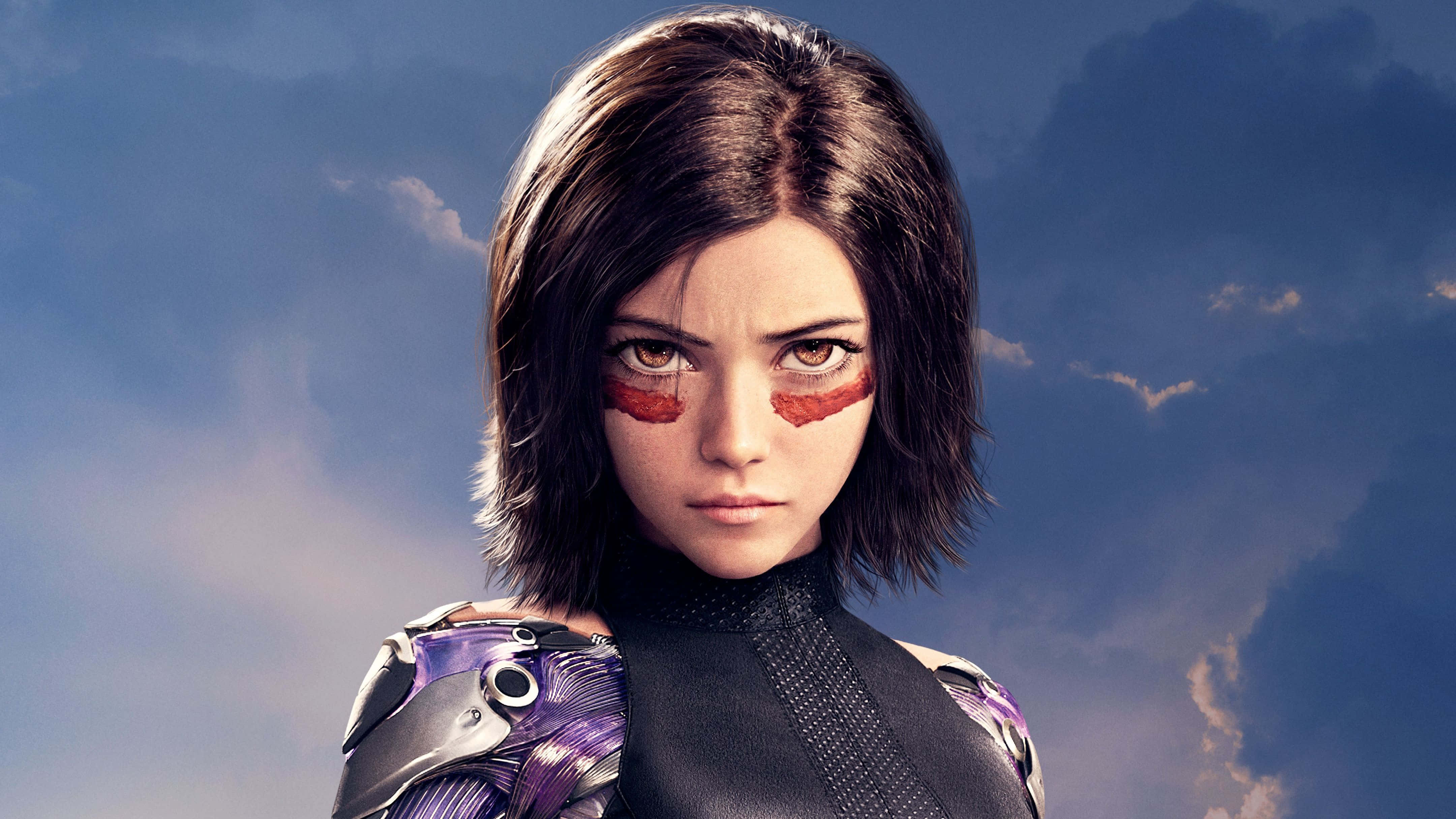 Alita Battle Angel 桌布 壁紙 — 一位兇猛的女戰士，身穿義體裝甲，帶有紅色眼睛標記，在陰天藍色天空下凝視著。