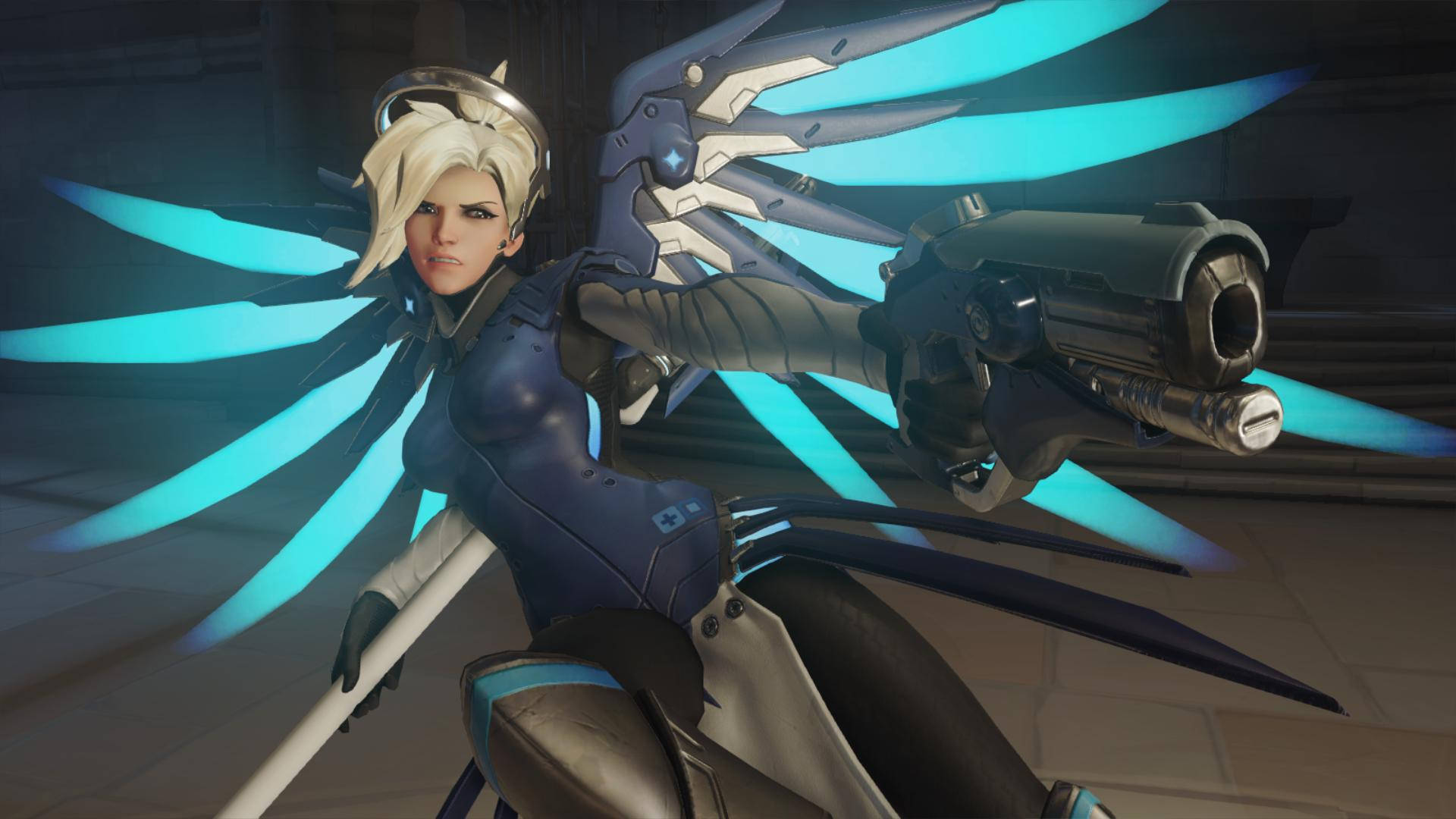 Mercy 桌布 壁紙 — 一位兇猛的女英雄，擁有發光的藍色翅膀和未來派武器，在昏暗的城市環境中準備就緒。