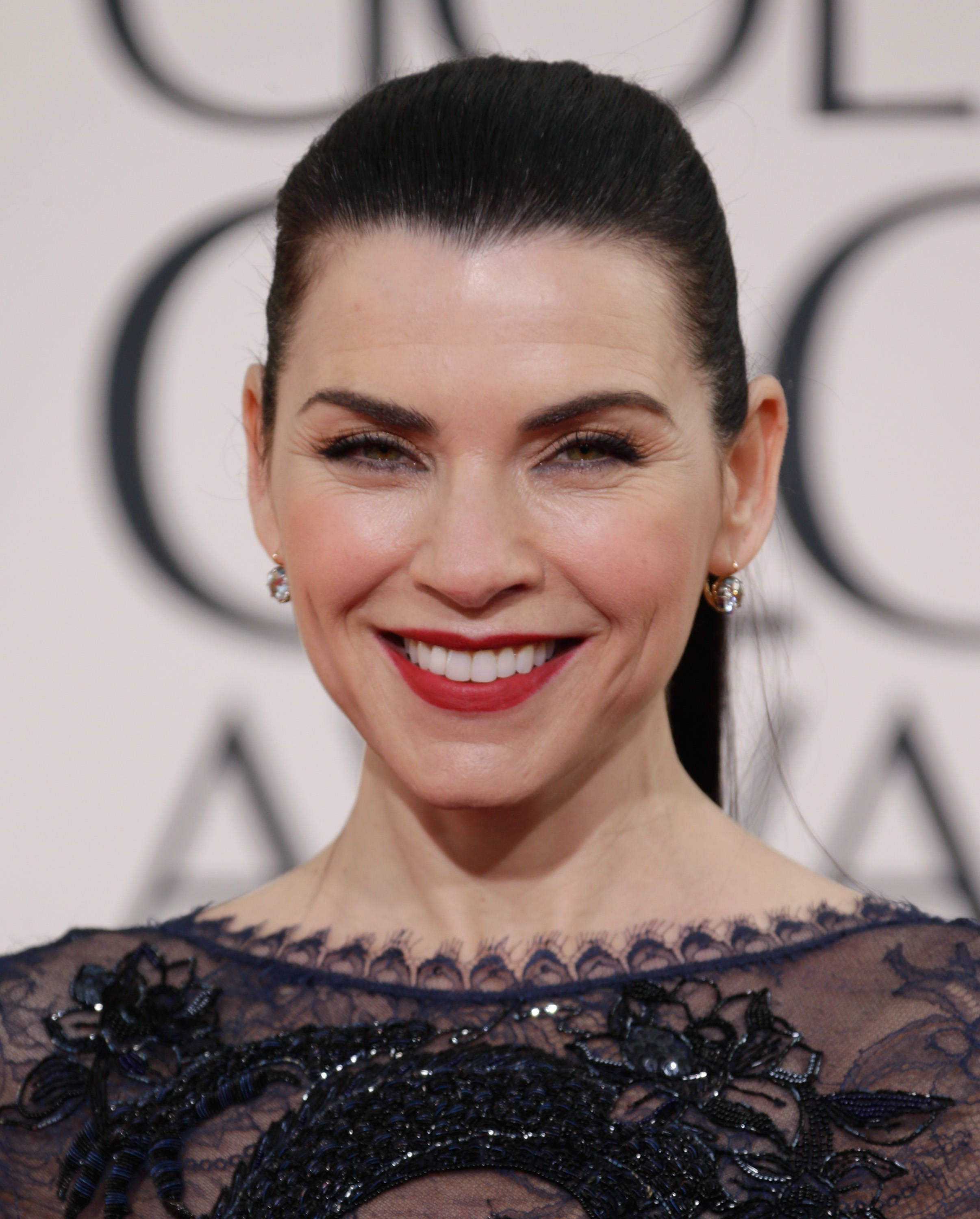 Celebrity 桌布 壁紙 — 一位光彩照人的女士，擁有光滑的黑髮和鮮豔的紅唇，身穿華麗的黑色蕾絲禮服在紅地毯活動上溫暖微笑。