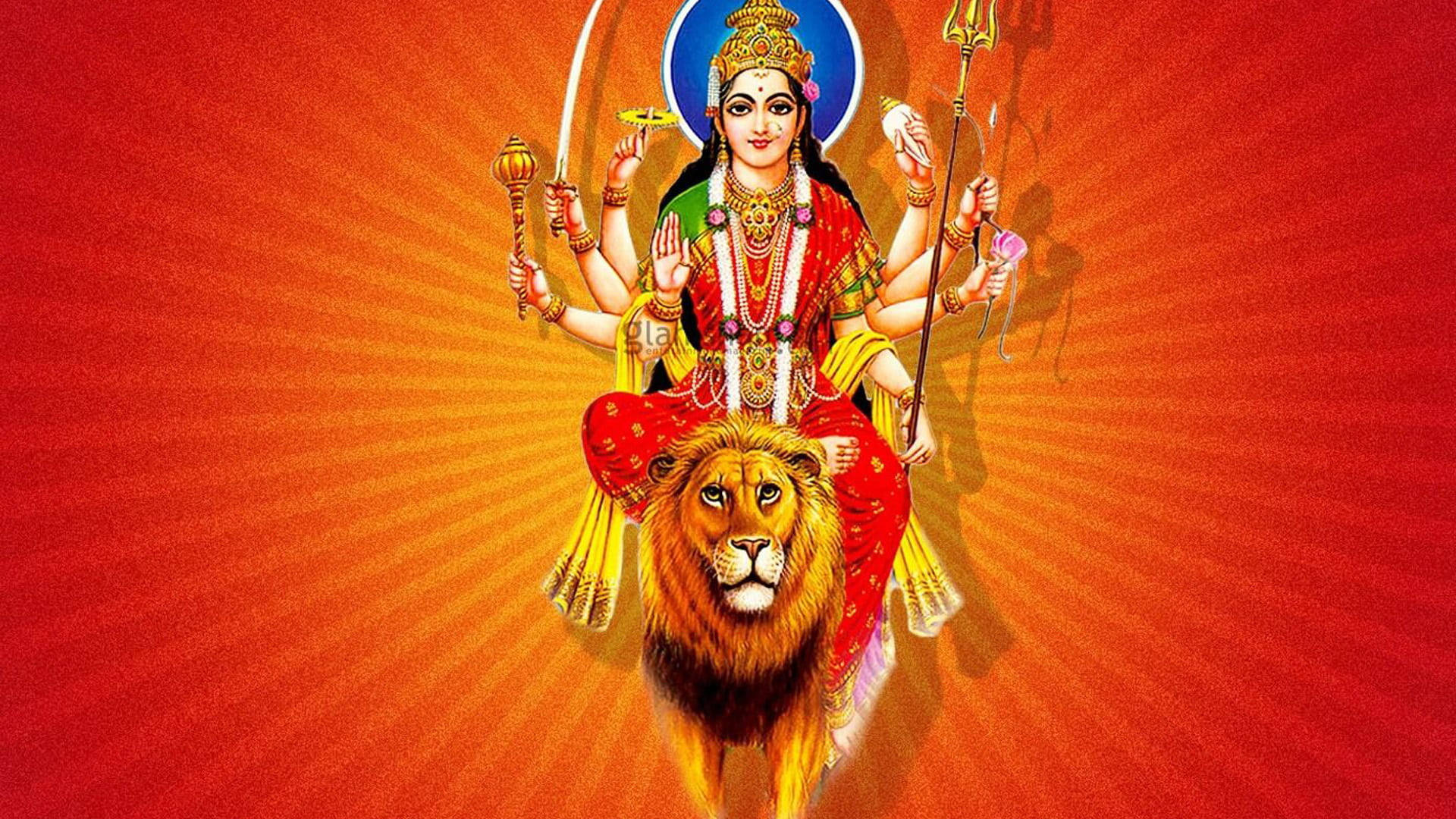 Indian 桌布 壁紙 — 一位光芒四射的多臂印度教女神騎著一頭雄偉的獅子，背景是熾熱的橙色太陽爆發。