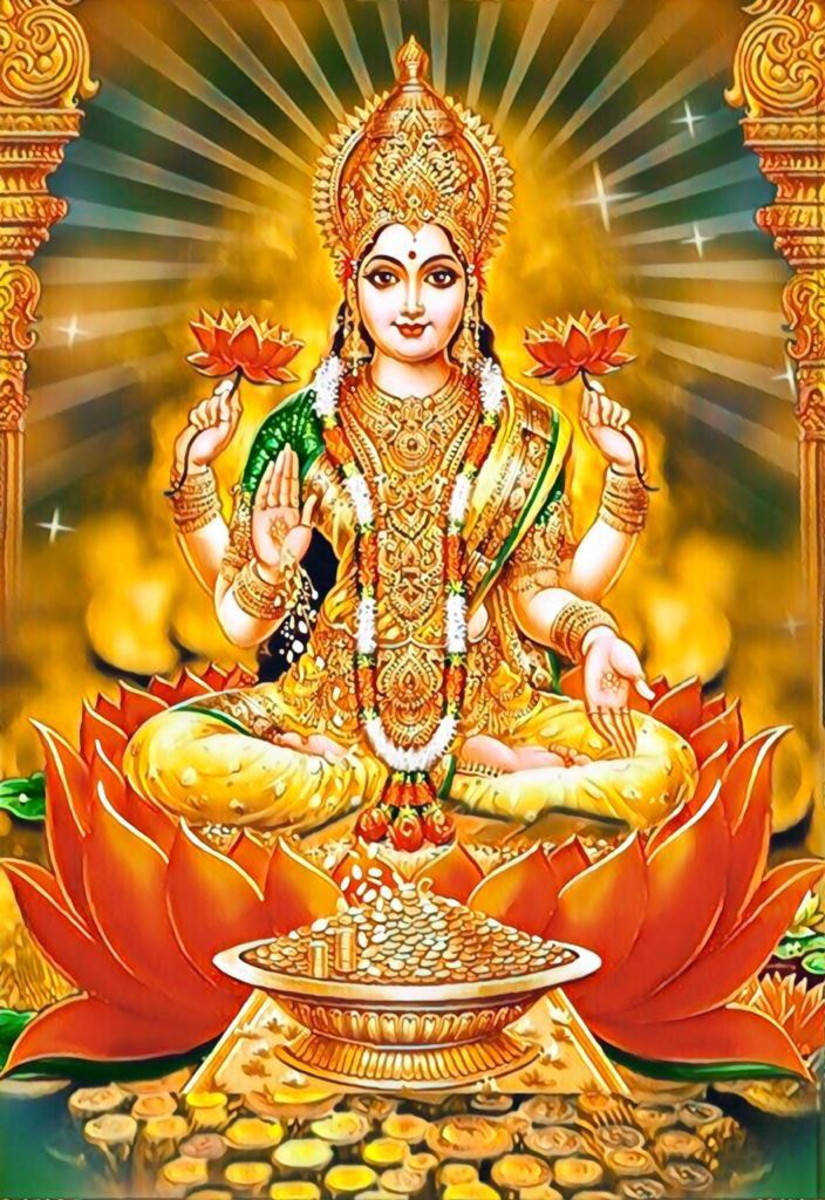 Lakshmi Devi 桌布 壁紙 — 一位光芒四射的多臂金色神祇安詳地坐在紅蓮花上，手持蓮花，周圍環繞著神聖的光芒和華麗的柱子。