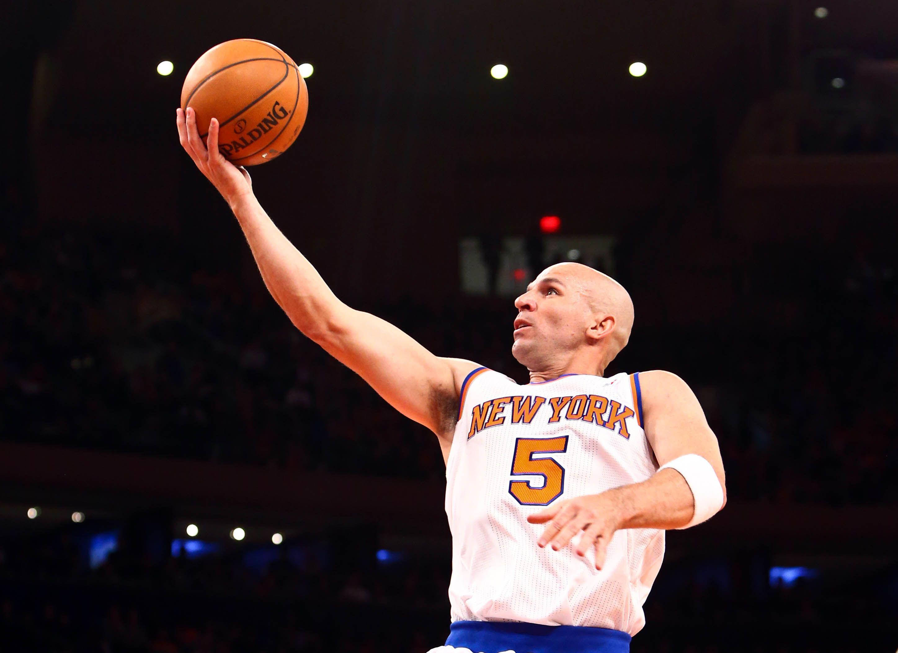 NBA 桌布 壁紙 — 一位光頭籃球運動員身穿紐約球衣，在場館燈光下投擲斯伯丁籃球，背景有模糊的觀眾。