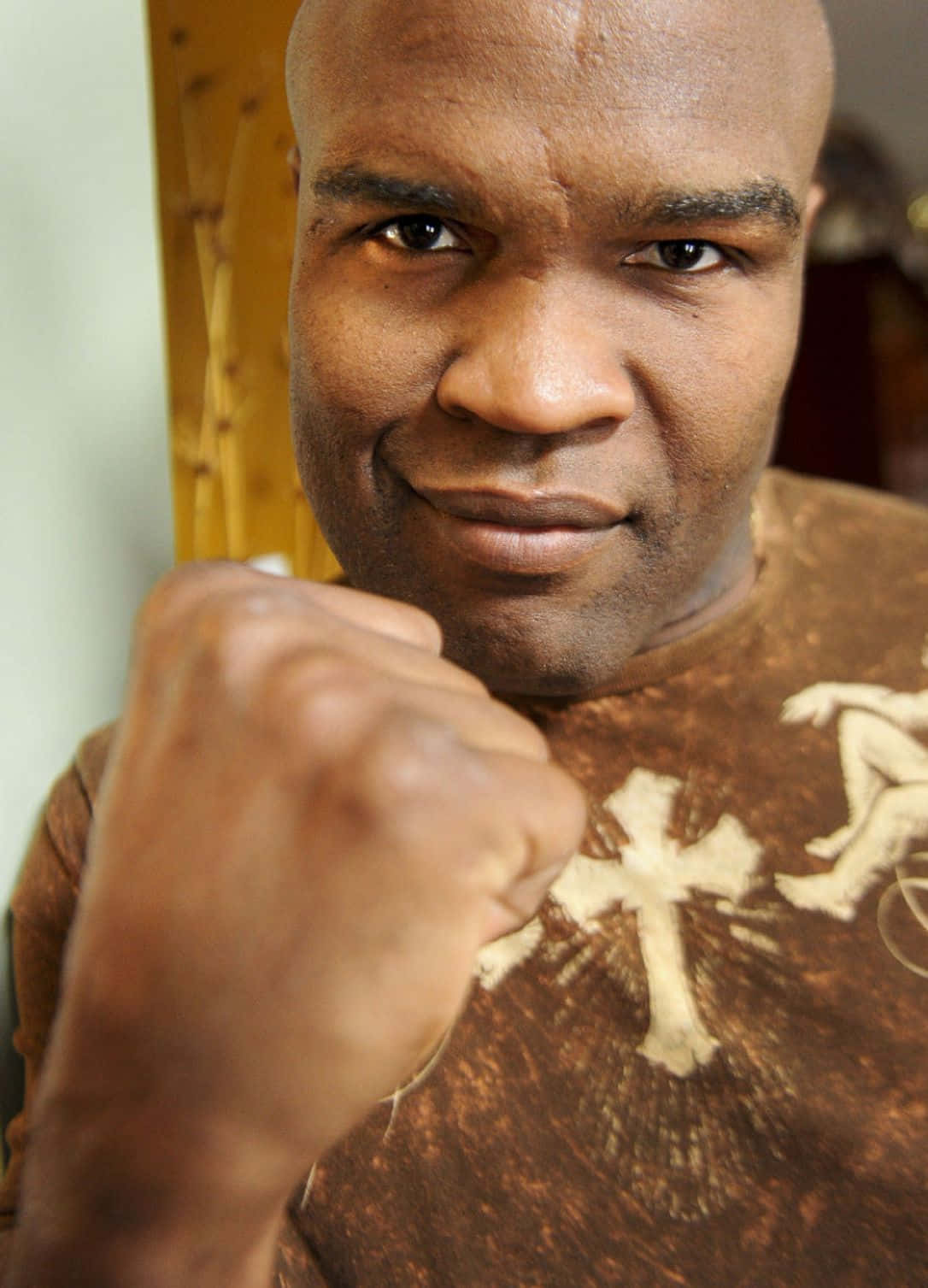 martial arts 桌布 壁紙 — 一位光頭黑人男子自信地微笑，握緊拳頭靠近下巴的特寫肖像。