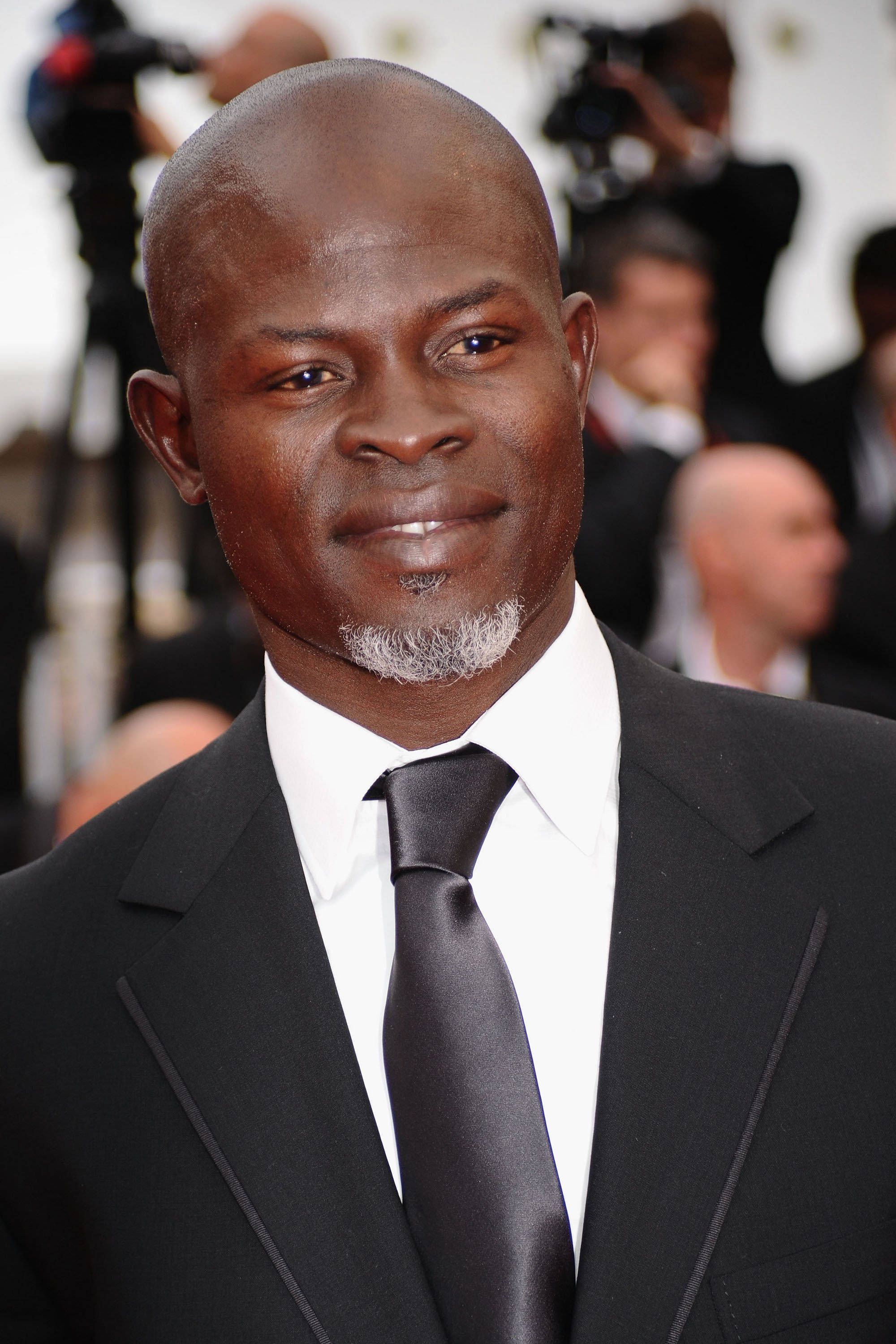 Celebrity 桌布 壁紙 — 一位光頭黑人男性留著灰色山羊鬍，穿著黑色西裝和領帶，在紅地毯活動中的特寫肖像。