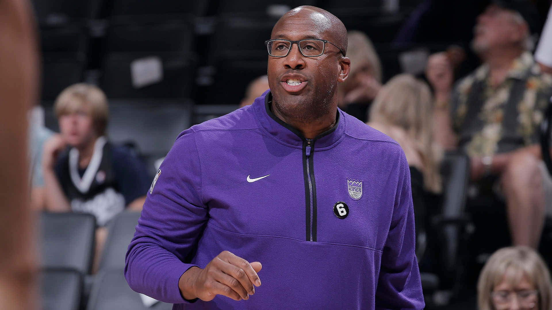 NBA 桌布 壁紙 — 一位光頭黑人籃球教練穿著紫色Nike外套，上有6號標誌，在比賽中生動地做手勢，背景有模糊的觀眾。