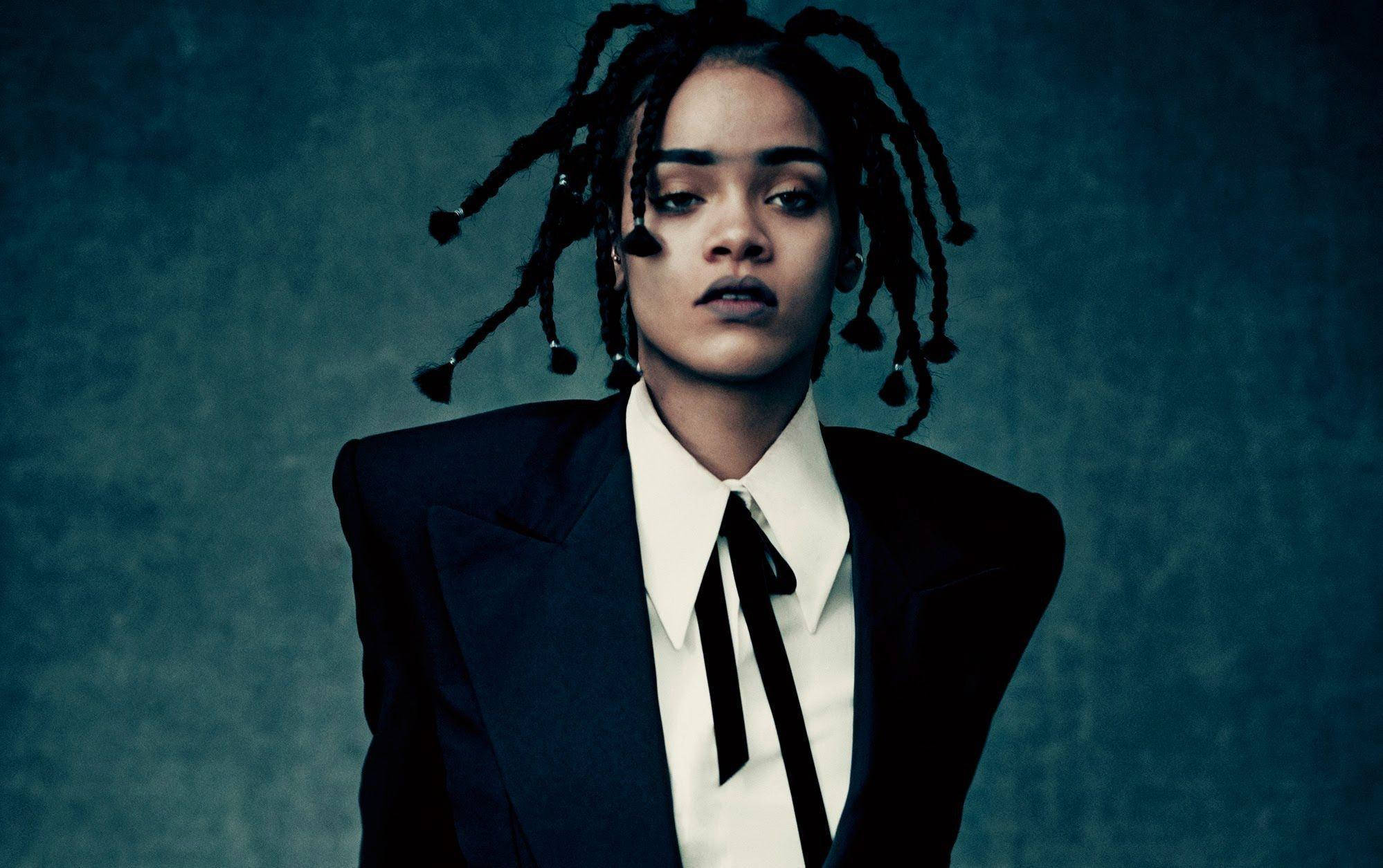 Celebrity 桌布 壁紙 — 一位冷靜的辮子女性，穿著俐落的黑色西裝和領結，背景是帶有紋理的青綠色。