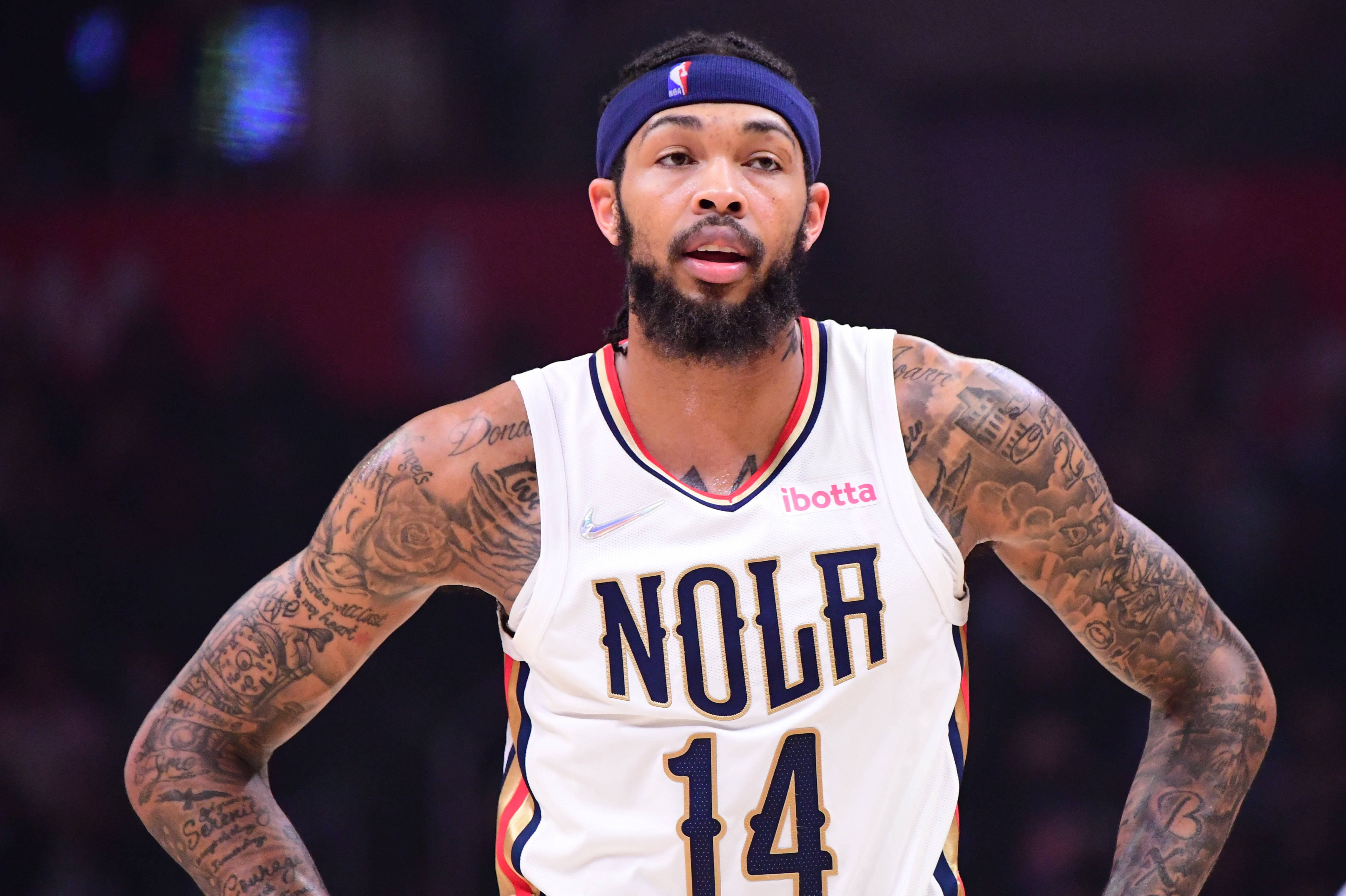 NBA 桌布 壁紙 — 一位刺青籃球運動員身穿白色NOLA球衣（14號），在比賽中雙手叉腰站立。