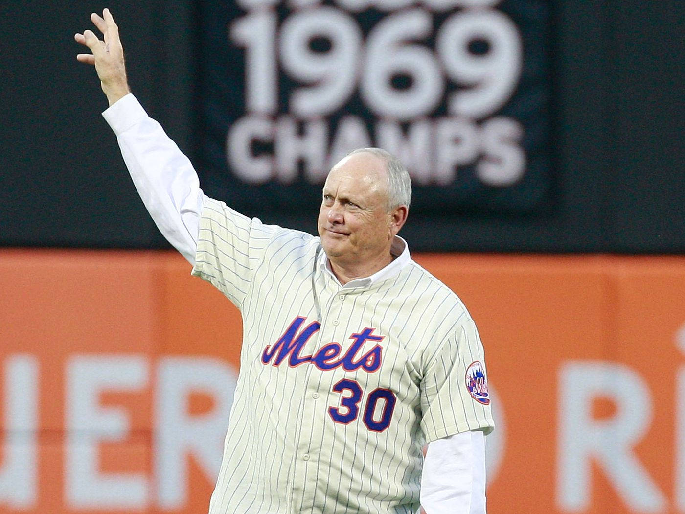 Nolan Ryan 桌布 壁紙 — 一位前紐約大都會棒球運動員穿著條紋球衣，在明亮的燈光下於球場活動中向球迷揮手。