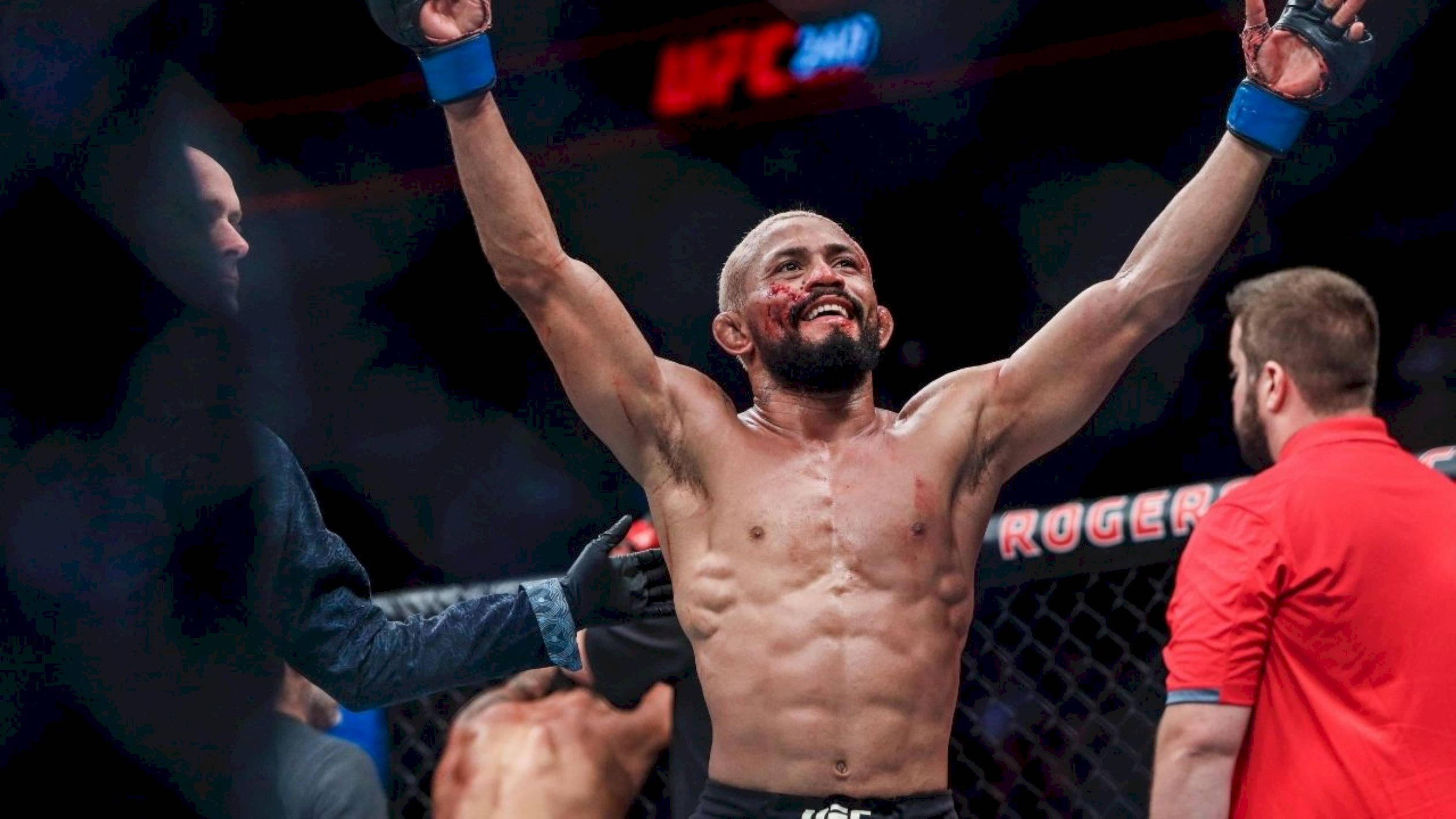 Victory 桌布 壁紙 — 一位勝利的UFC拳手，滿臉鮮血，高舉雙臂，在明亮的競技場燈光下於八角籠內慶祝勝利。