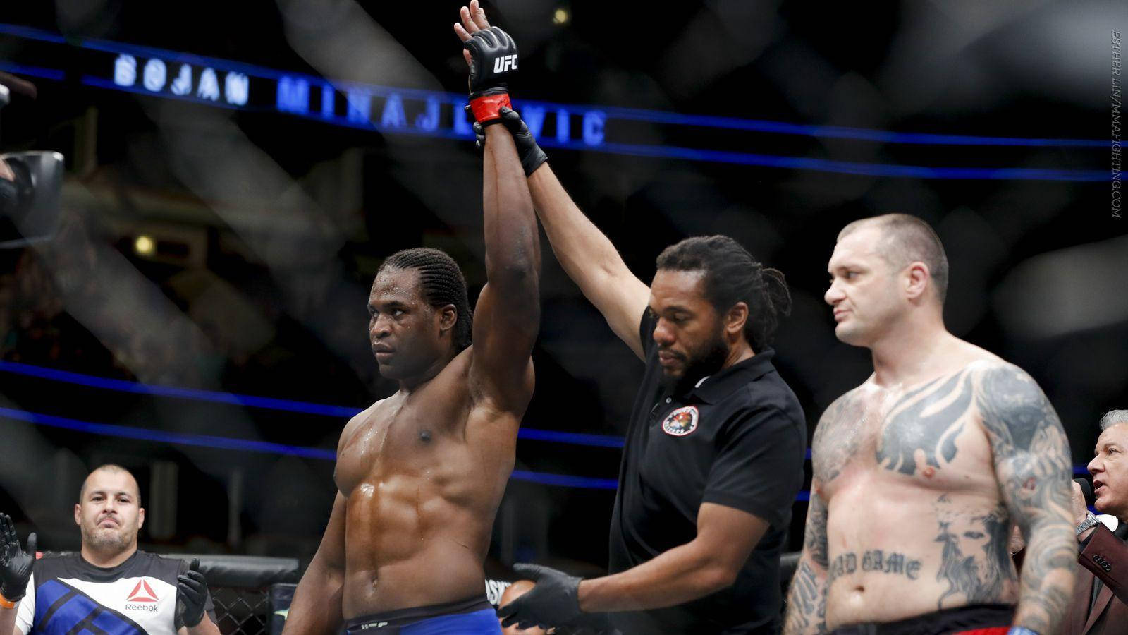 Victory 桌布 壁紙 — 一位勝利的UFC拳手在八角籠內被裁判宣佈為勝者時舉起手臂。