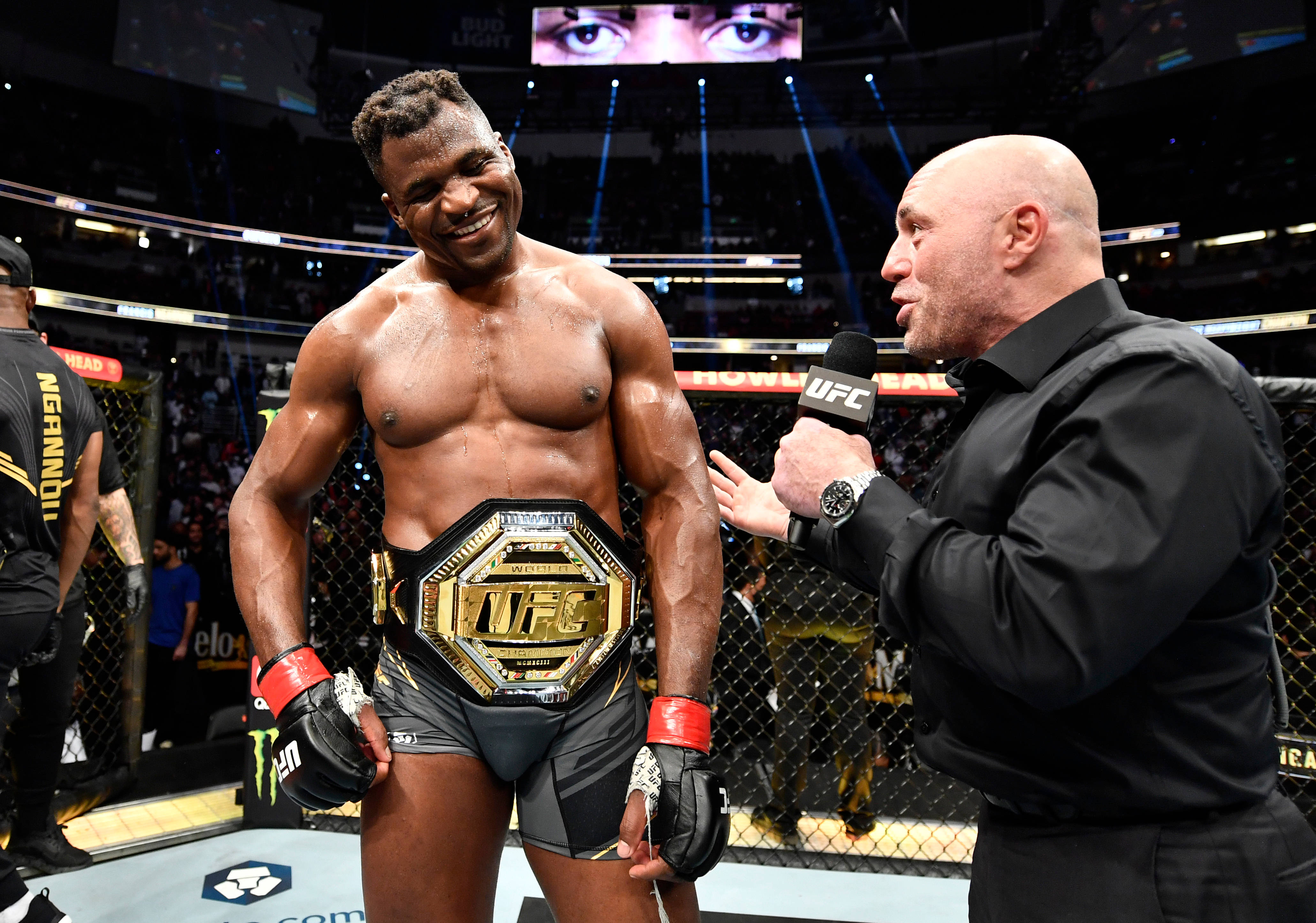 UFC 桌布 壁紙 — 一位勝利的UFC拳手在八角籠賽後採訪中手持冠軍腰帶，笑容燦爛。