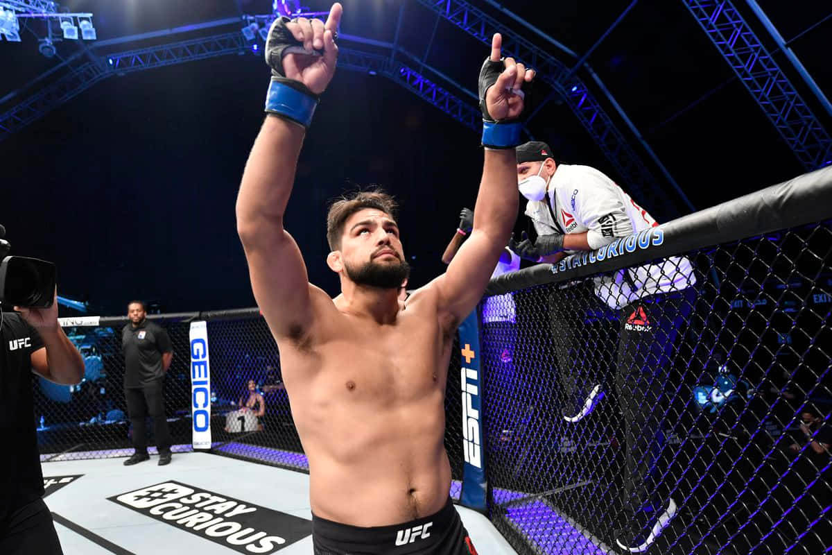 MMA 桌布 壁紙 — 一位勝利的UFC拳手在明亮的場館燈光下，於八角籠內高舉雙臂慶祝勝利。