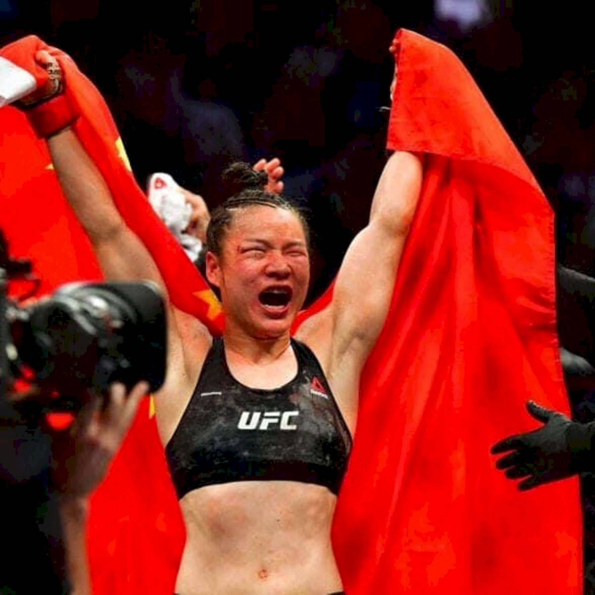 Champion 桌布 壁紙 — 一位勝利的女性UFC拳手在八角籠中高舉紅色中國國旗，發出原始情感的吶喊。