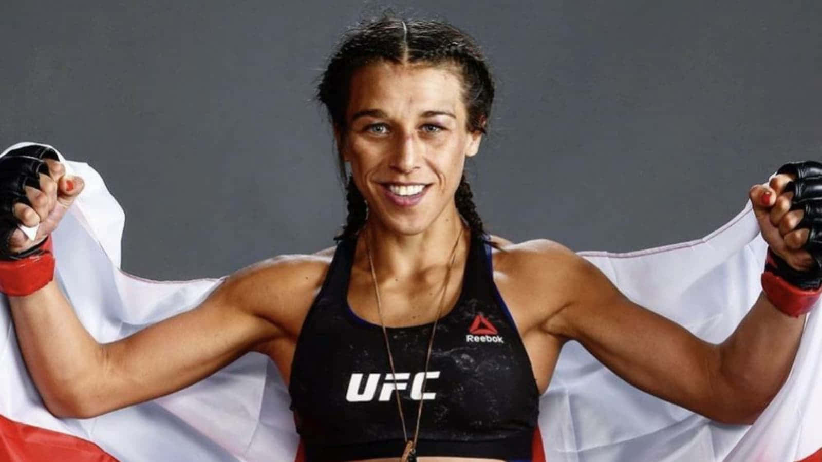 Flag 桌布 壁紙 — 一位勝利的女性UFC拳手在攝影棚中高舉波蘭國旗，露出燦爛的笑容。