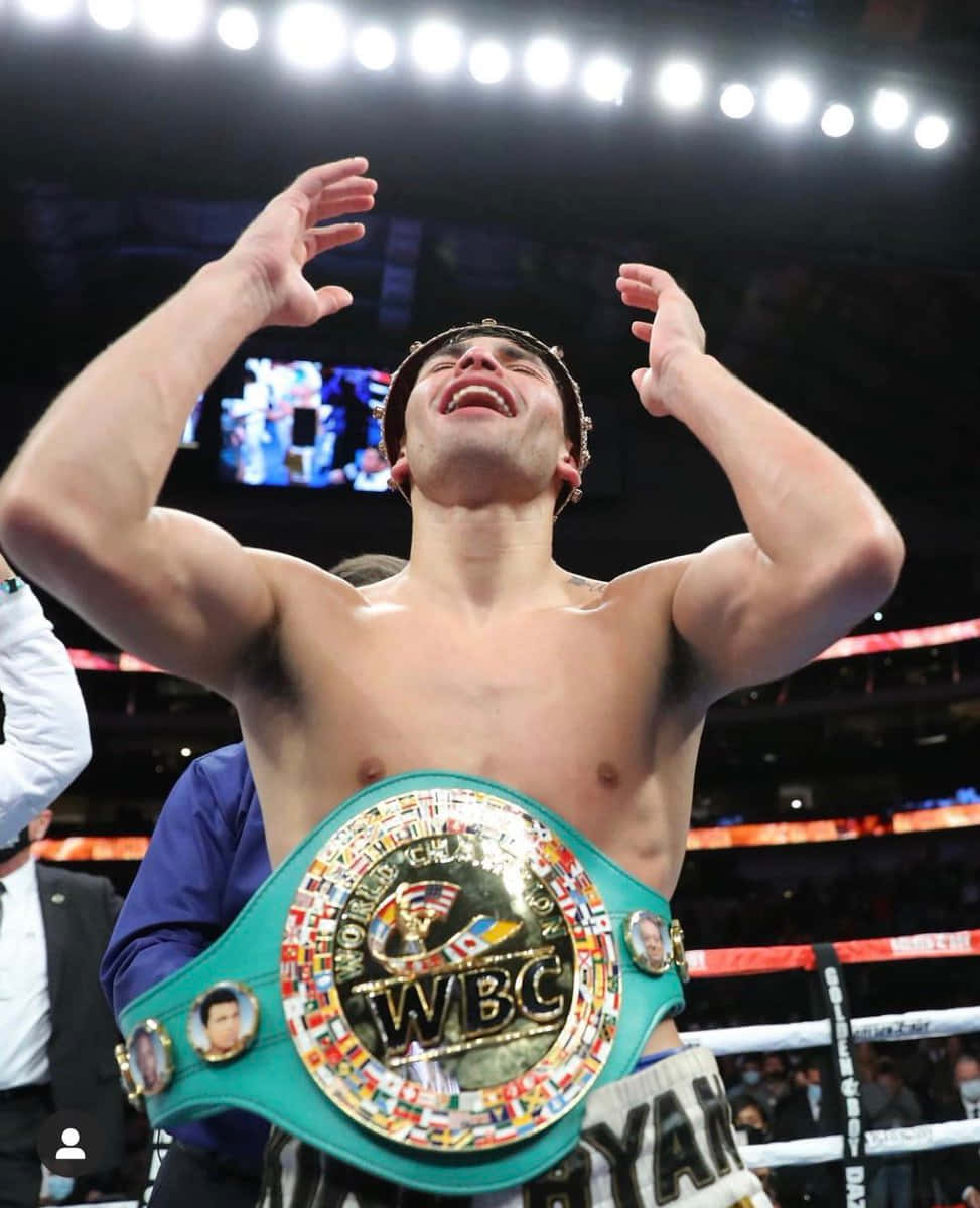 Belt 桌布 壁紙 — 一位勝利的拳擊手在拳擊台上高舉雙臂慶祝勝利，身上佩戴著WBC冠軍腰帶，在明亮的場館燈光下。