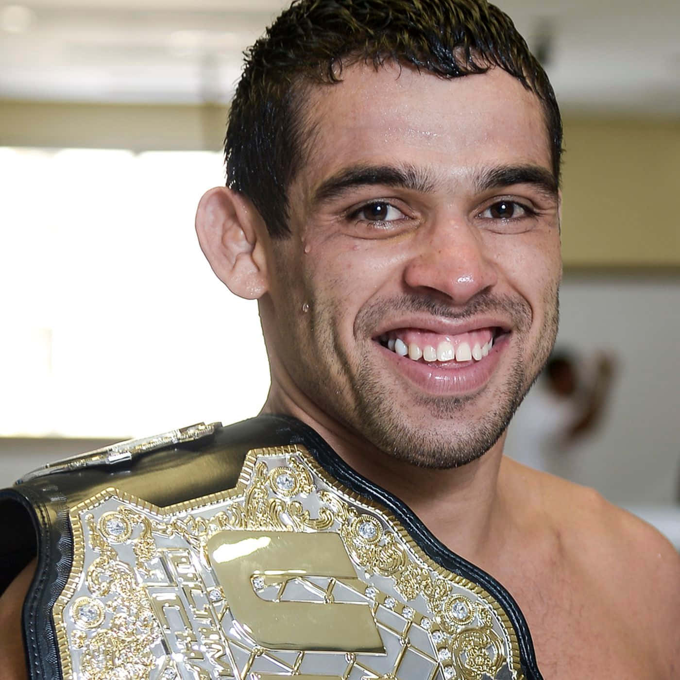 UFC 桌布 壁紙 — 一位勝利的混合武術家滿懷喜悅，自豪地展示他閃閃發光的冠軍腰帶。