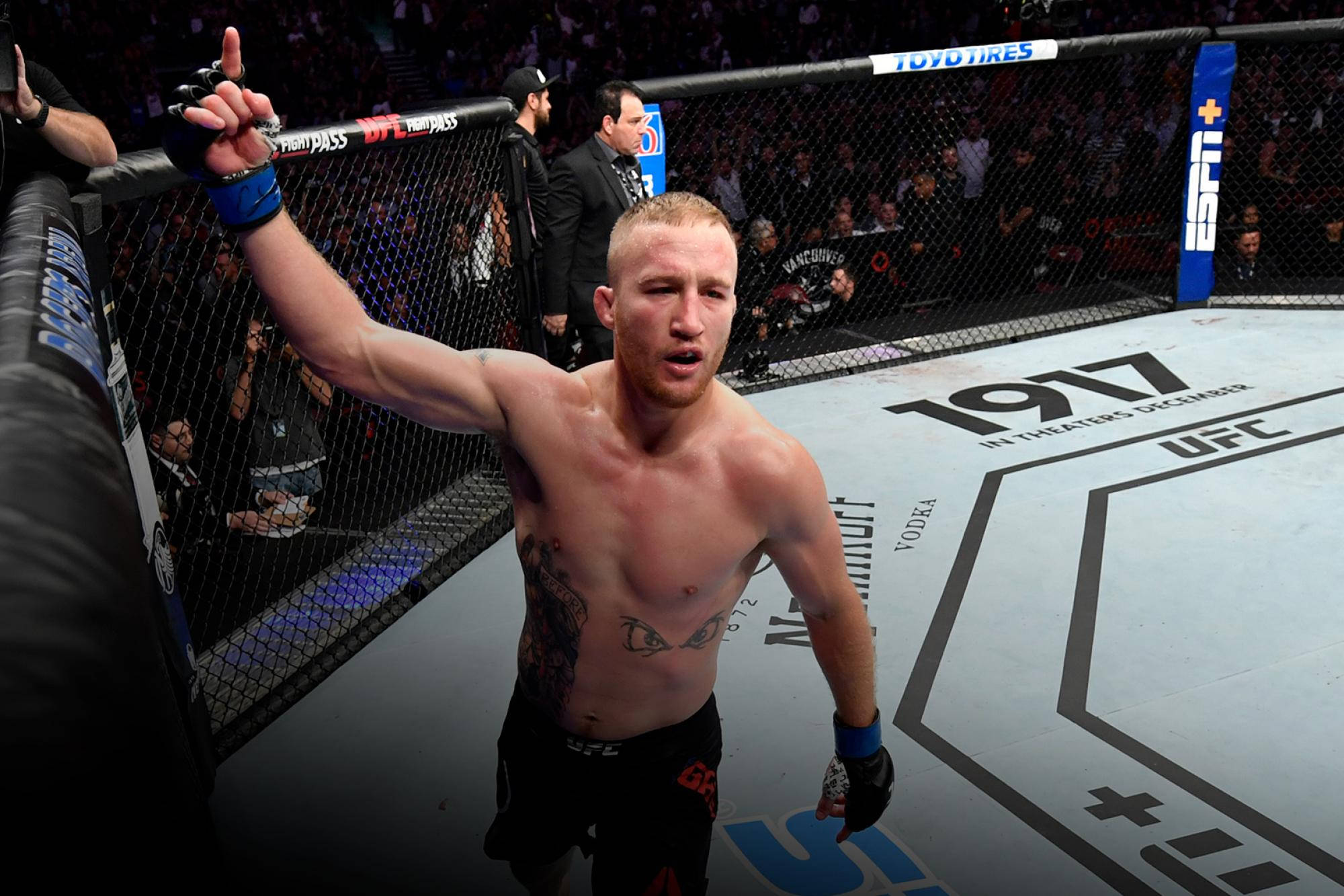 UFC 桌布 壁紙 — 一位勝利的混合武術選手在UFC八角籠內高舉勝利之手，圍欄後有歡呼的人群。