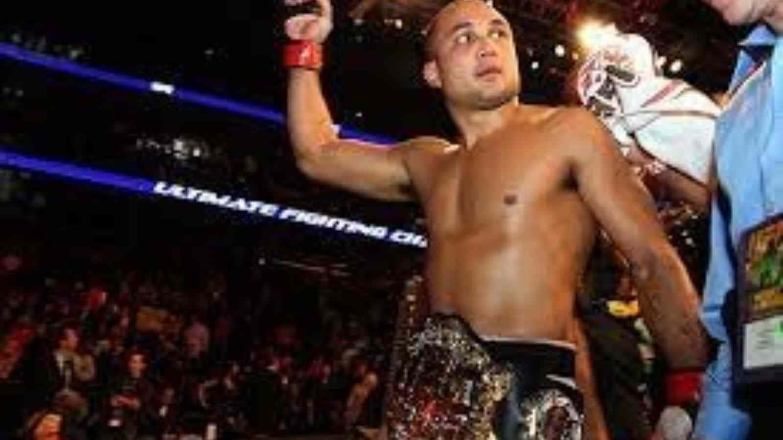 UFC 桌布 壁紙 — 一位勝利的綜合格鬥家在燈光明亮的UFC八角籠內高舉手臂慶祝勝利，周圍是歡呼的人群。