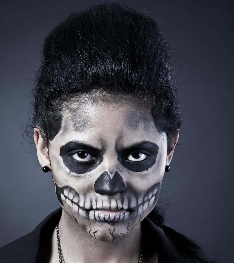 Halloween Face Paint 桌布 壁紙 — 一位化著精緻骷髏妝容的女性，在深灰色背景下強烈凝視。