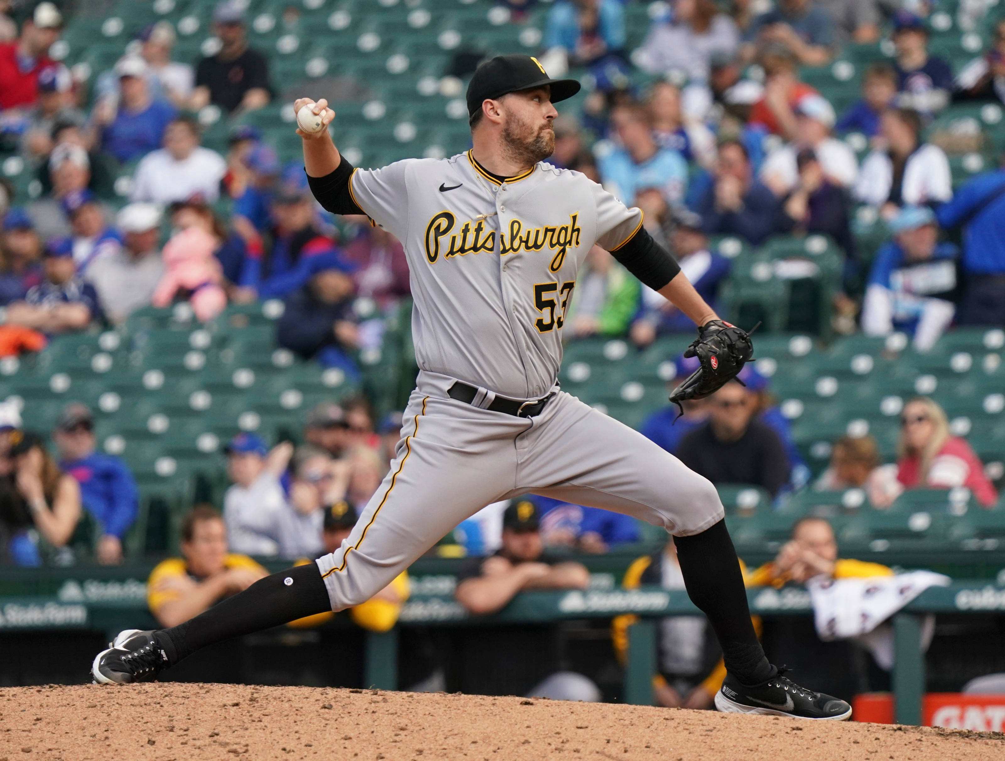 Pittsburgh Pirates 桌布 壁紙 — 一位匹茲堡海盜隊投手在陽光明媚的棒球投手丘上投球，身後是模糊的綠色座位人群。