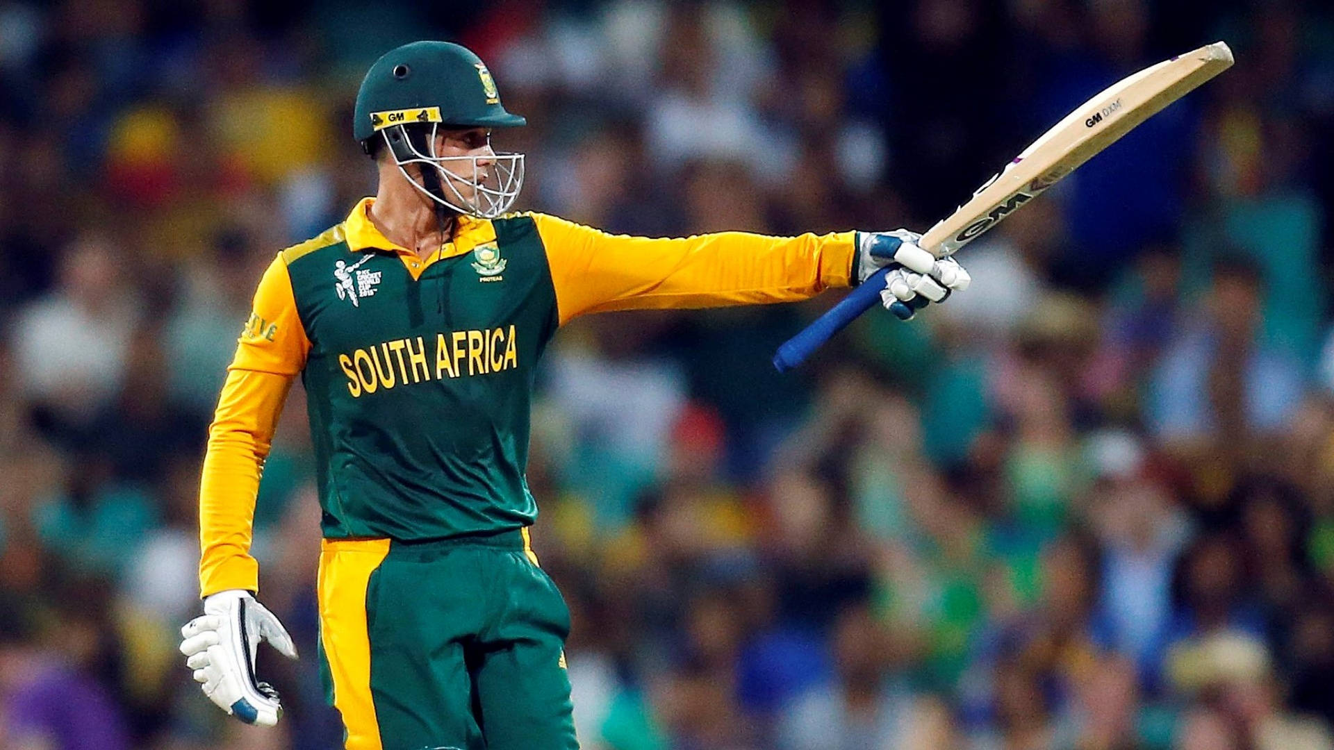 quinton de kock 桌布 壁紙 — 一位南非板球運動員身穿綠色和黃色球衣，在夜間比賽中於體育場燈光下高舉球棒慶祝勝利。