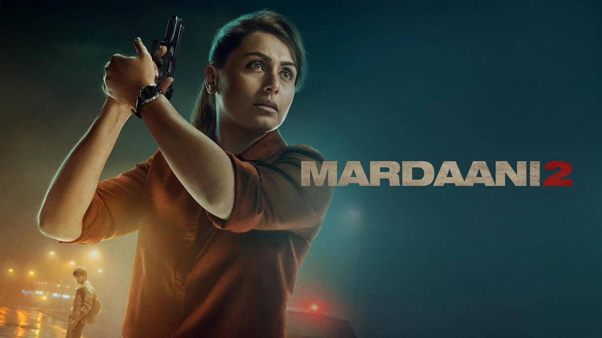 Rani Mukerji 桌布 壁紙 — 一位堅定的女性穿著橙色襯衫，在夜晚用手槍瞄準，身後的城市燈光閃爍。