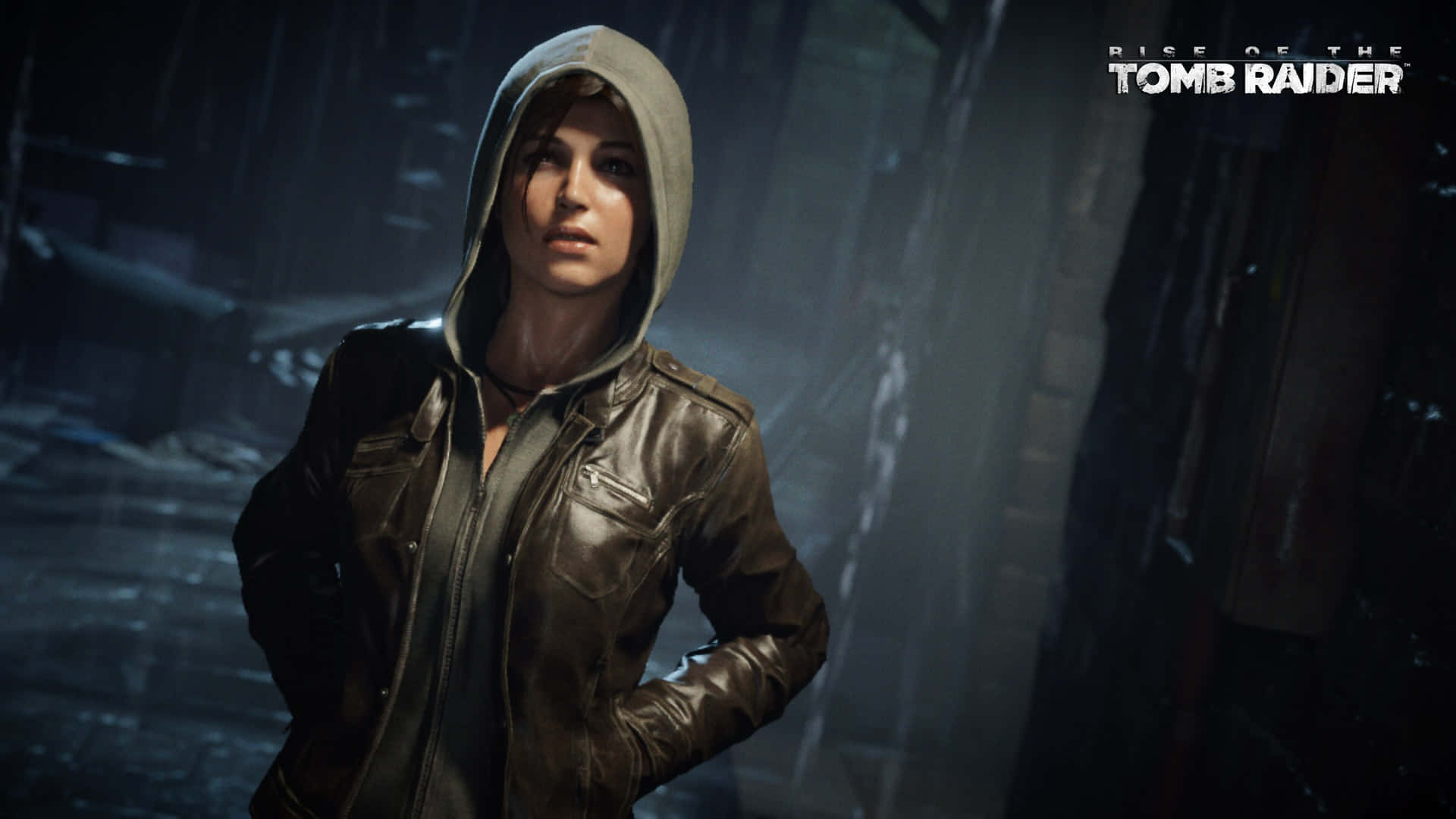 Rise Of The Tomb Raider 桌布 壁紙 — 一位堅定的女性身穿連帽外套，站在燈光昏暗、雨水浸濕的城市小巷中，霧氣在她周圍繚繞。