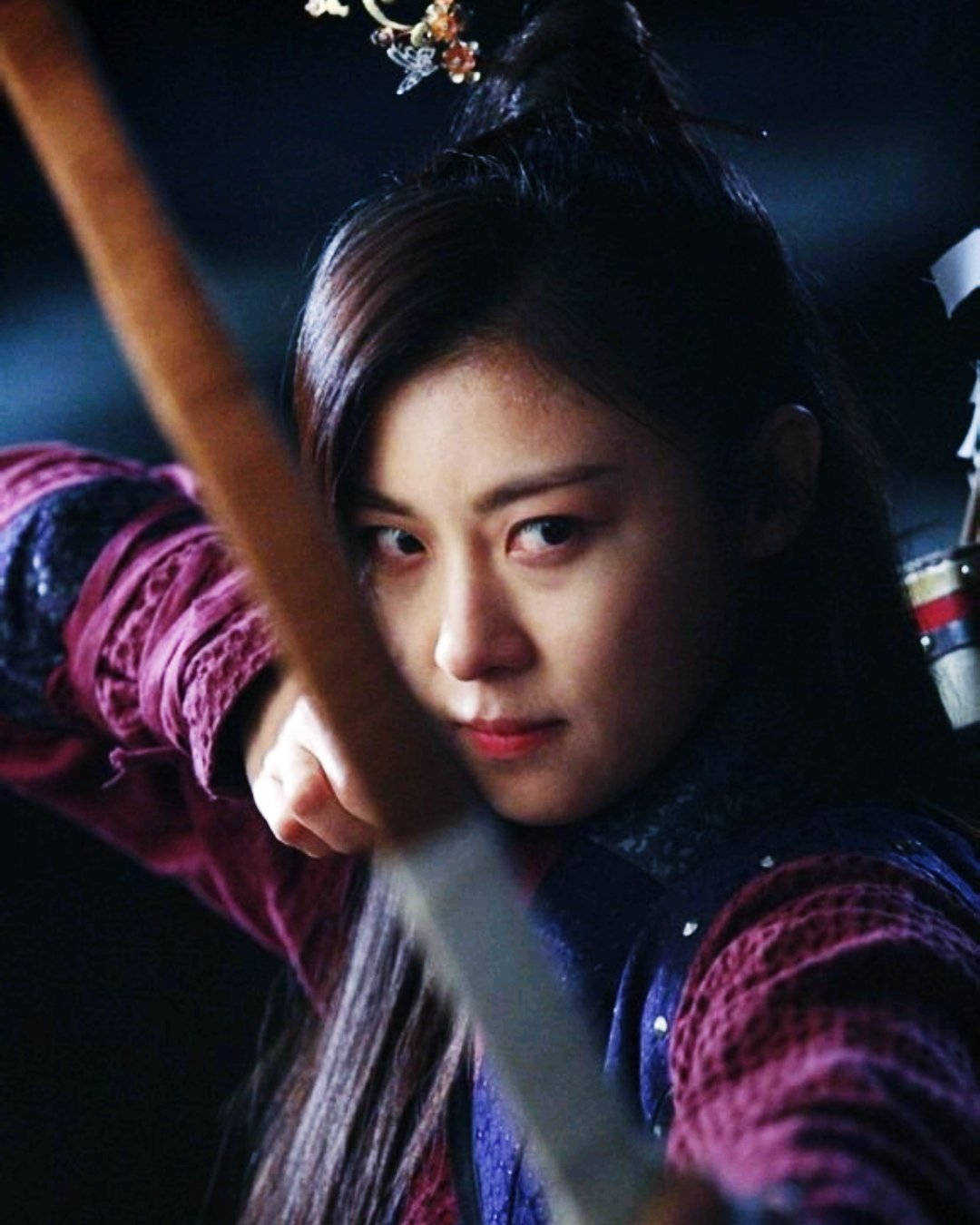 kdrama 桌布 壁紙 — 一位堅定的女戰士，深色頭髮，戴著華麗的髮夾，在昏暗的場景中握著劍。