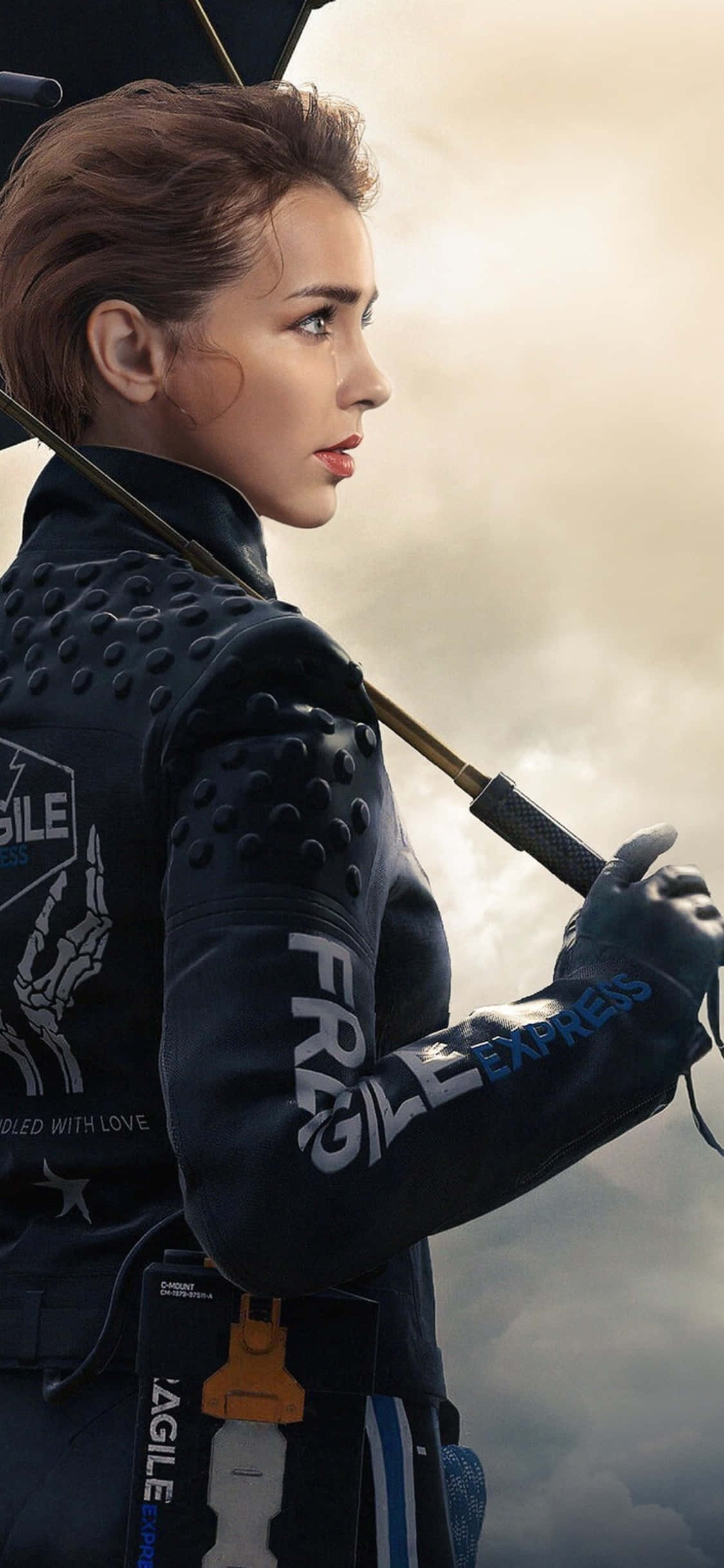 iPhone Xs Death Stranding 桌布 壁紙 — 一位堅定的女戰士身穿黑色裝甲服，在陰雲密佈的天空下手持法杖。