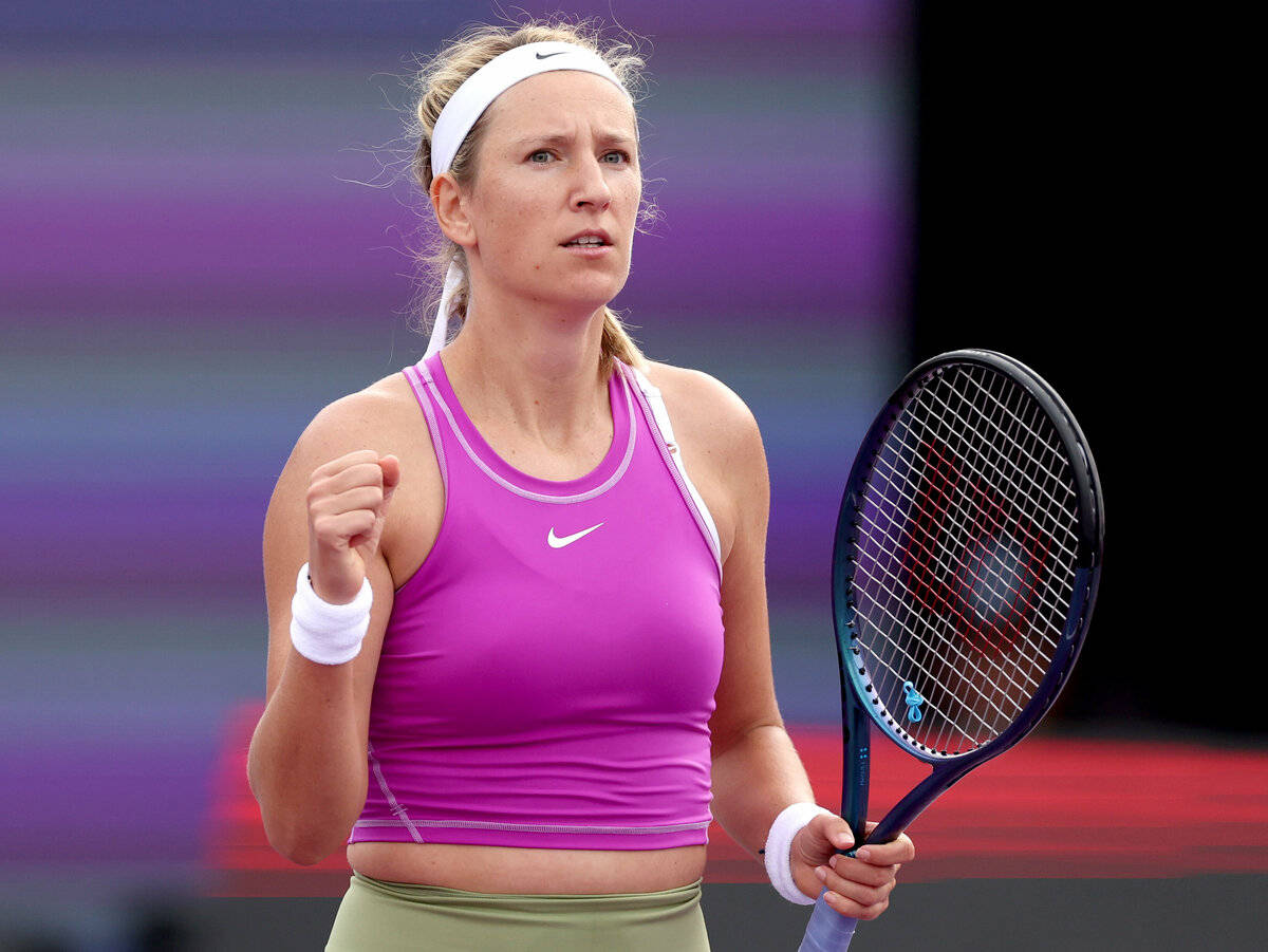 Athletic 桌布 壁紙 — 一位堅定的女網球運動員穿著鮮豔的粉紅色上衣，在色彩繽紛的球場上握緊拳頭慶祝，同時拿著球拍。