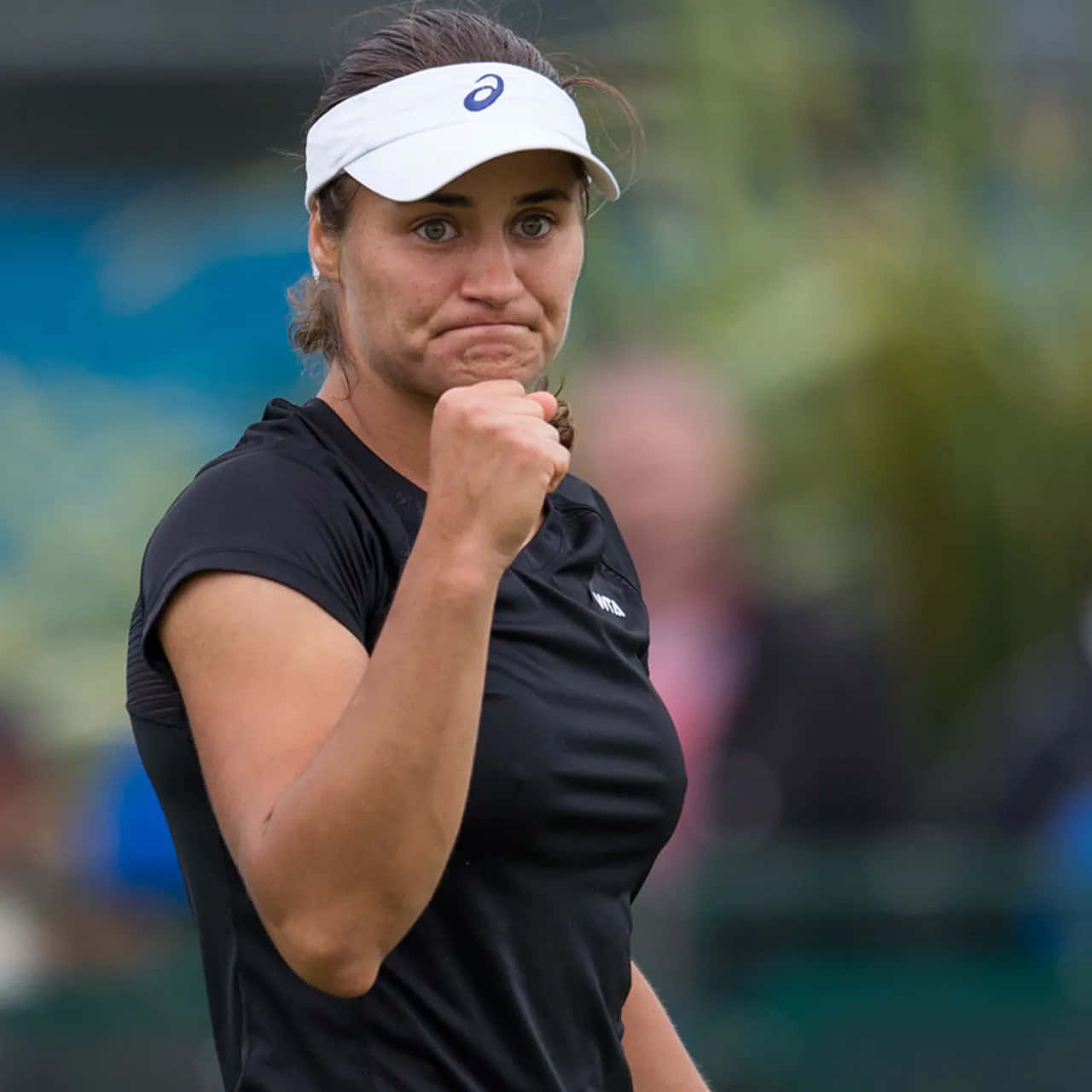 網球 桌布 壁紙 — 一位堅定的女網球選手在比賽中緊握拳頭、咬緊牙關，展現高度專注。
