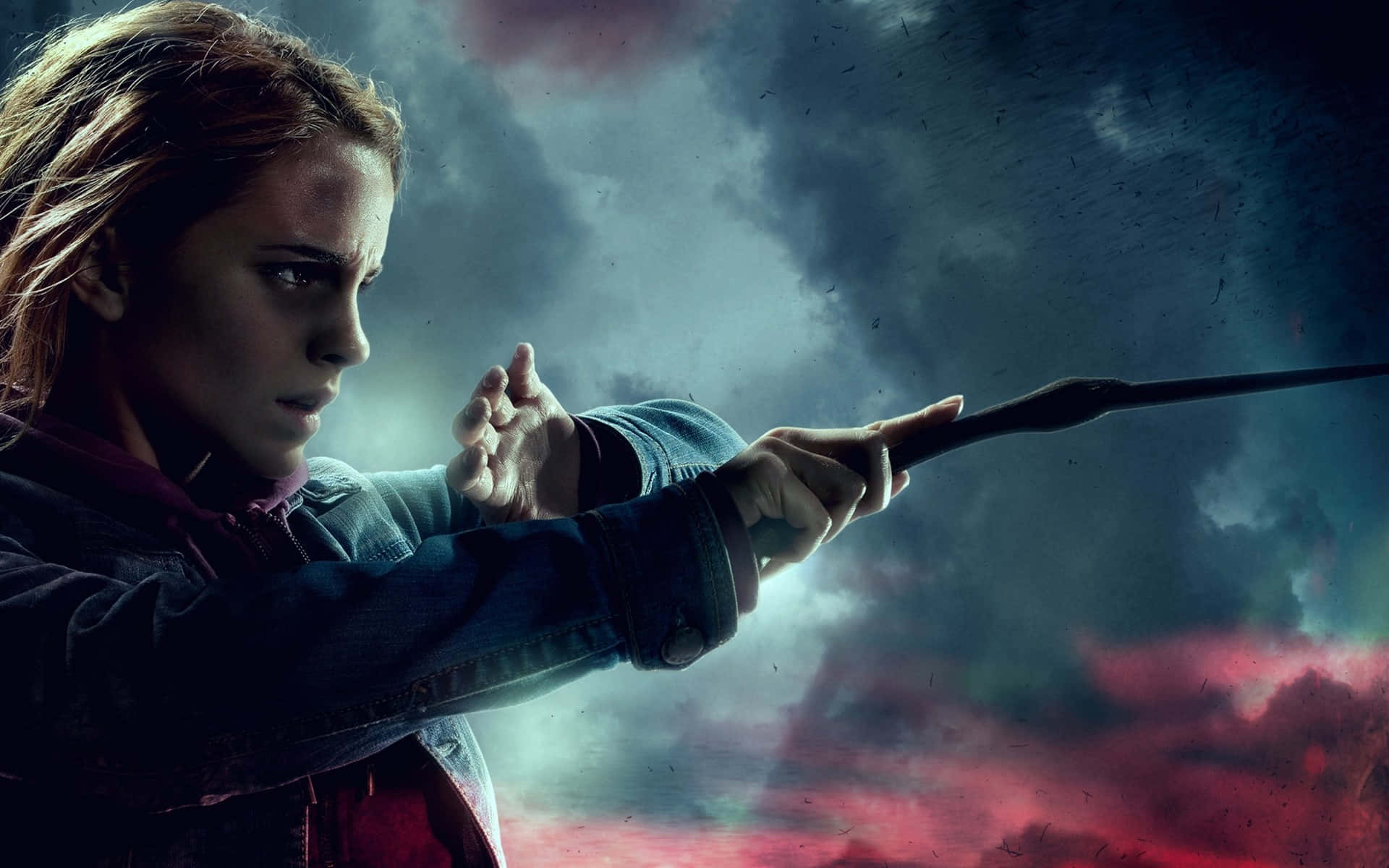 Hermione Granger 桌布 壁紙 — 一位堅定的年輕女子揮舞魔杖，對抗佈滿紅色和灰色雲層的暴風雨天空。