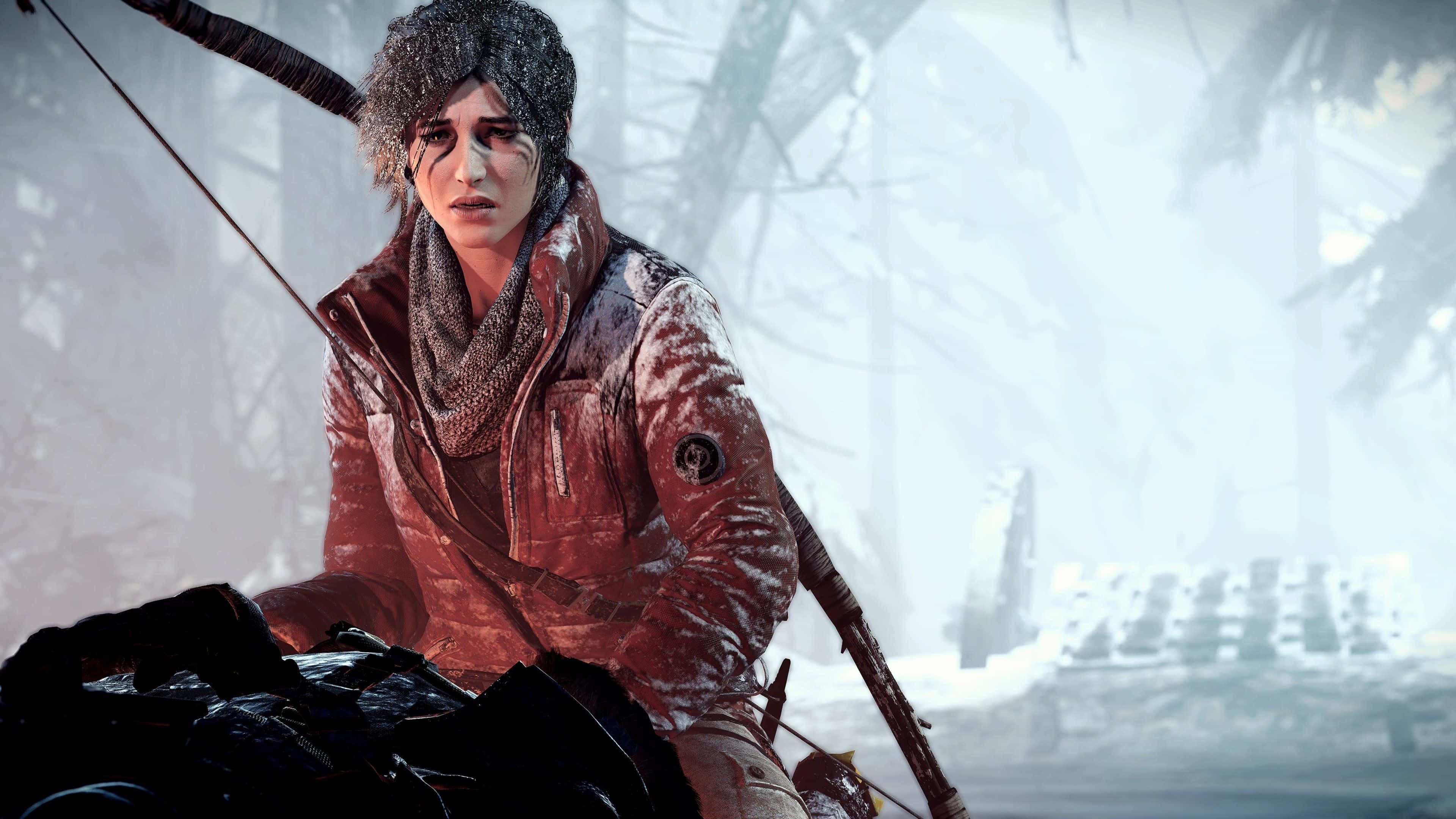 Lara Croft 桌布 壁紙 — 一位堅定的年輕女子穿著雪覆蓋的冬季外套和毛帽，在一個有光禿樹木和遠處廢墟的冰霜森林中拿著弓。