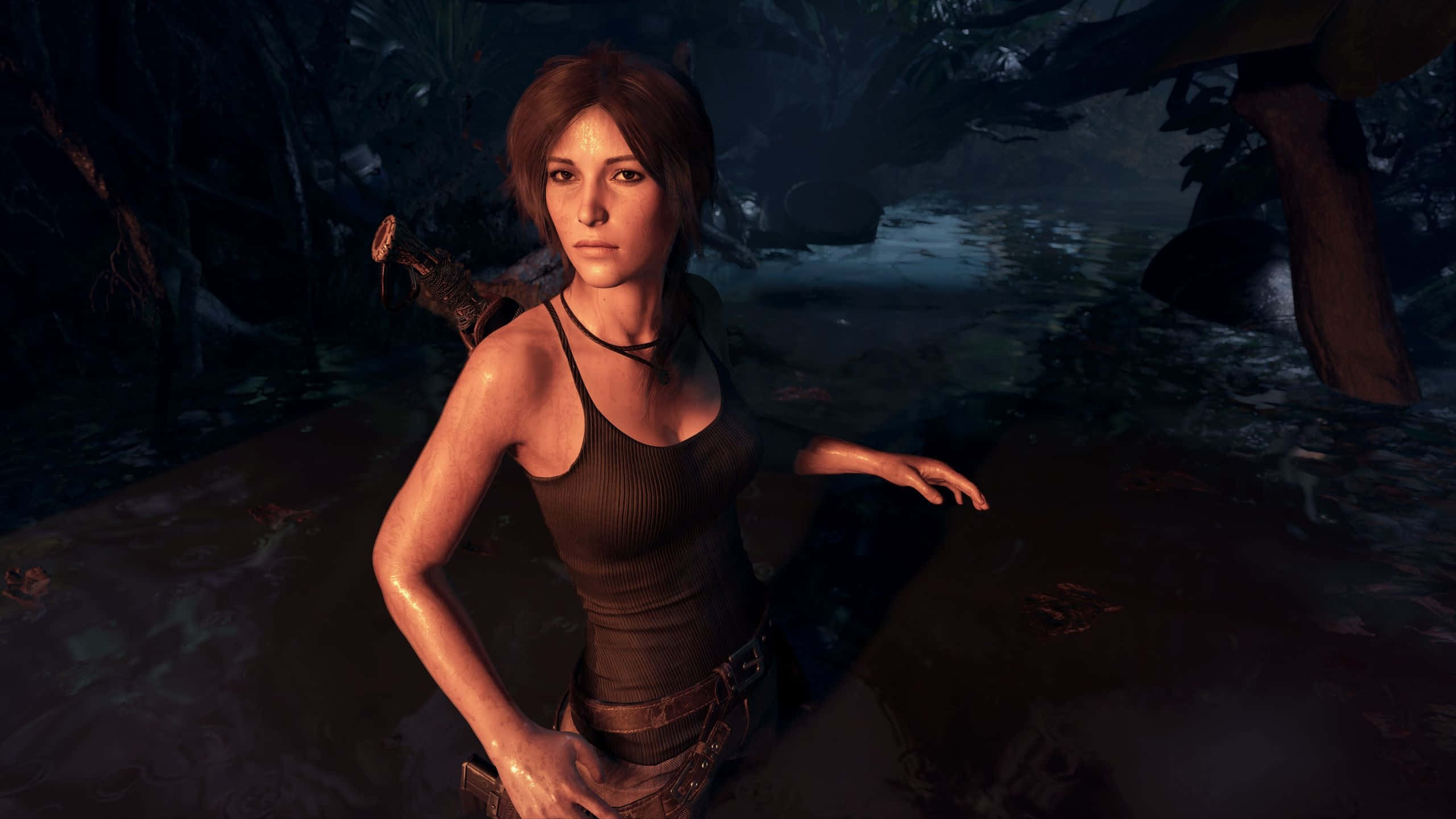 1440p Shadow Of The Tomb Raider 桌布 壁紙 — 一位堅定的探險家在昏暗的森林光線下，穿越泥濘的叢林水域，背景有藤蔓和古代遺跡。