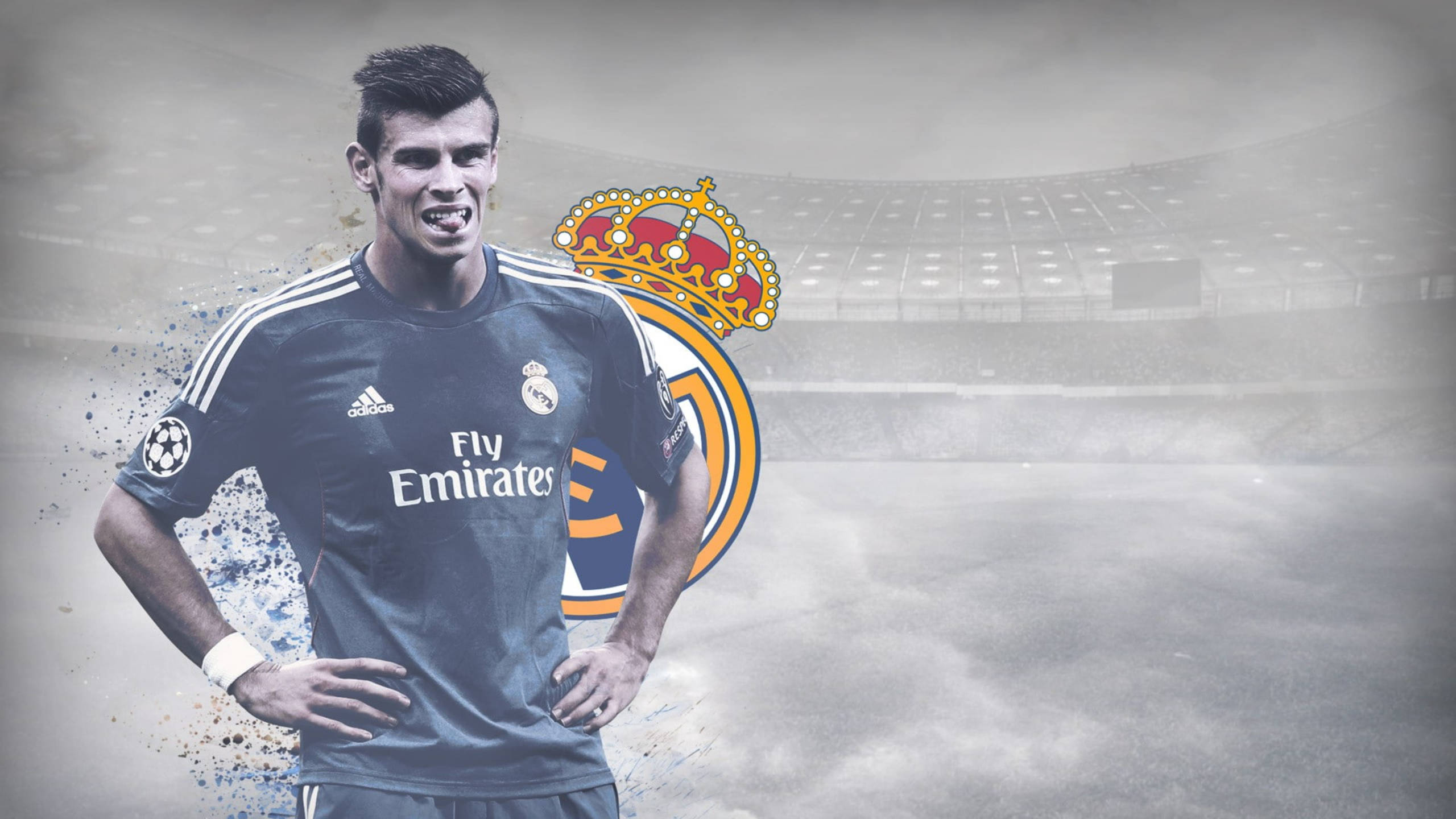 Gareth Bale 桌布 壁紙 — 一位堅定的足球員身穿皇家馬德里球衣，雙手叉腰，自信地站在模糊的球場背景前。