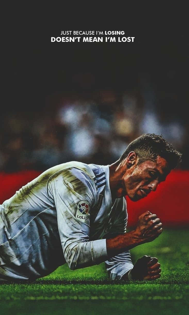 Football Quotes 桌布 壁紙 — 一位堅定的足球運動員跪在草地上，專注力極強，文字宣告『只是因為我輸了，並不代表我迷失了』。