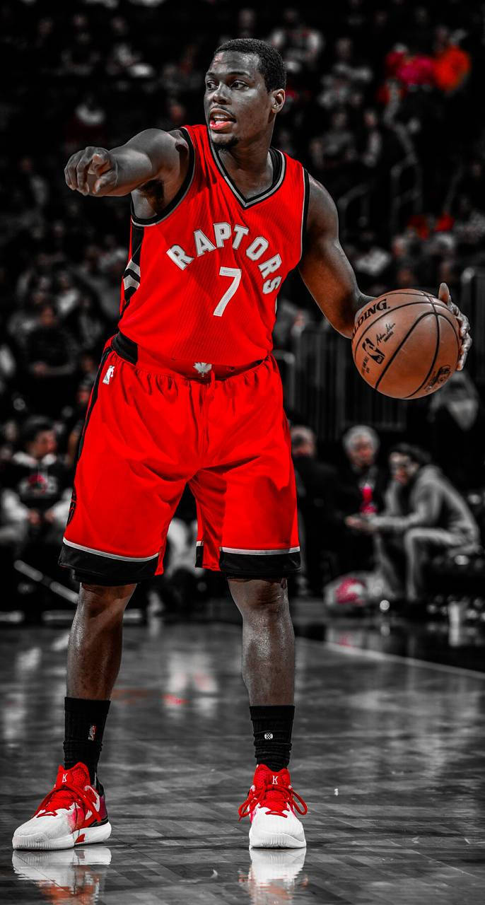 Lowry 桌布 壁紙 — 一位多倫多暴龍隊籃球運動員身穿紅色7號球衣，在黑白人群背景的比賽中專注地運球。