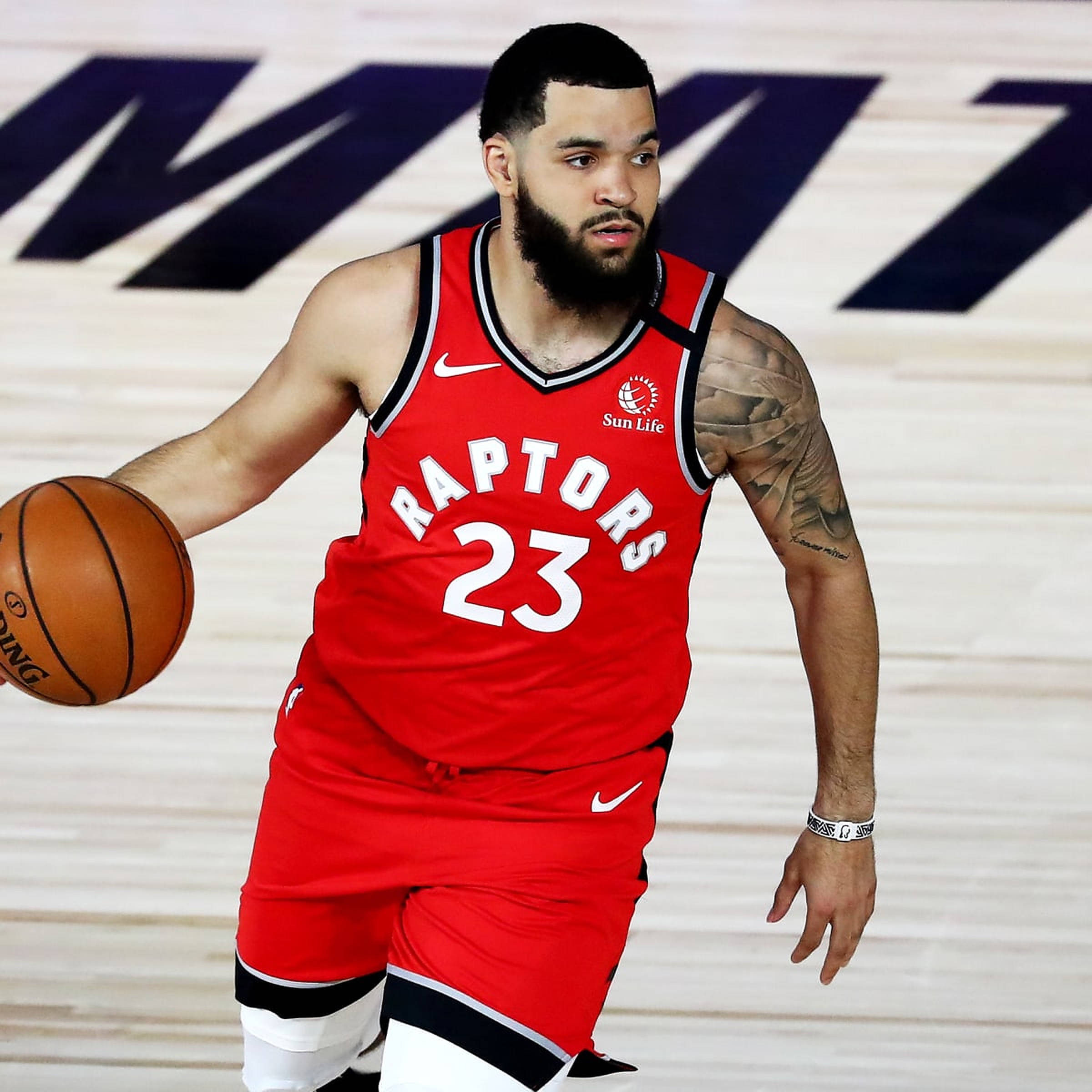 Fred Vanvleet 桌布 壁紙 — 一位多倫多暴龍隊籃球運動員身穿紅色球衣，在球場上專注地運球。