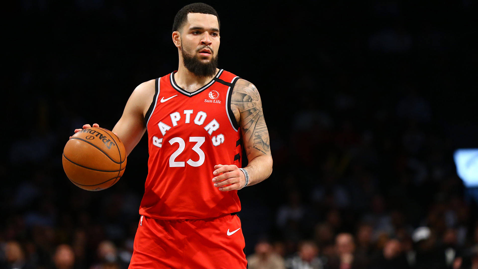 Fred Vanvleet 桌布 壁紙 — 一位多倫多暴龍隊籃球運動員身穿紅色23號球衣，在場館燈光下於比賽中運球。
