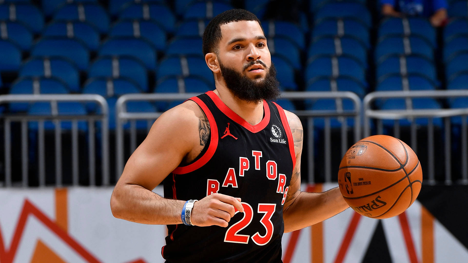 Fred Vanvleet 桌布 壁紙 — 一位多倫多暴龍隊籃球運動員身穿黑紅色球衣，在室內球場專注地拿著籃球。