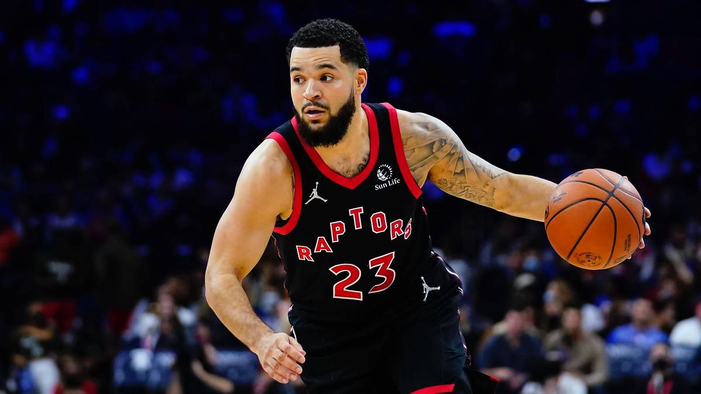 Fred Vanvleet 桌布 壁紙 — 一位多倫多暴龍隊籃球運動員身穿黑紅球衣，在明亮的場館燈光下專注地運球。