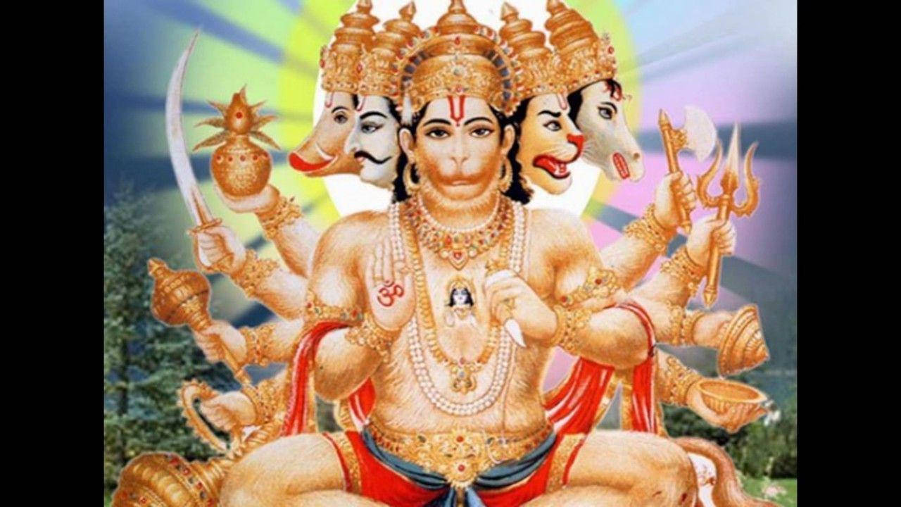Anjaneya 桌布 壁紙 — 一位多臂印度教神祇，擁有象頭和馬頭，佩戴黃金珠寶，手持神聖武器，背景是光芒四射的宇宙。
