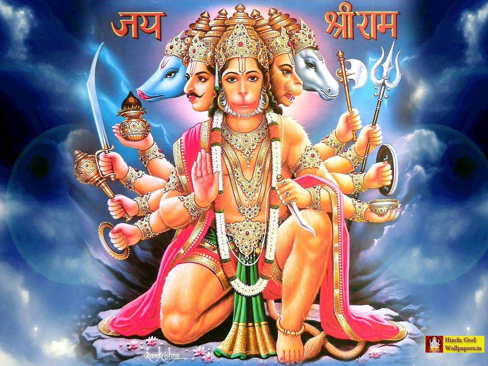 hanuman ji HD 桌布 壁紙 — 一位多臂印度教神祇，有藍色和白色的猴頭，跪著，飾有金飾和粉綠色衣服，背景是暴風雨的藍天。